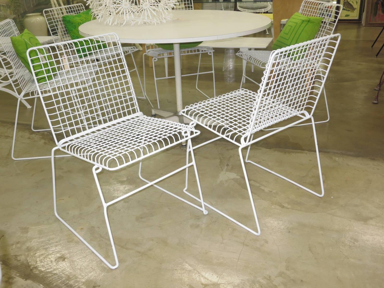 Set of 6 wire mesh chairs in the style of Harry Bertoia. White finish is in good condition. All are sturdy and solid. Neatly stackable for storage.  Priced per chair.