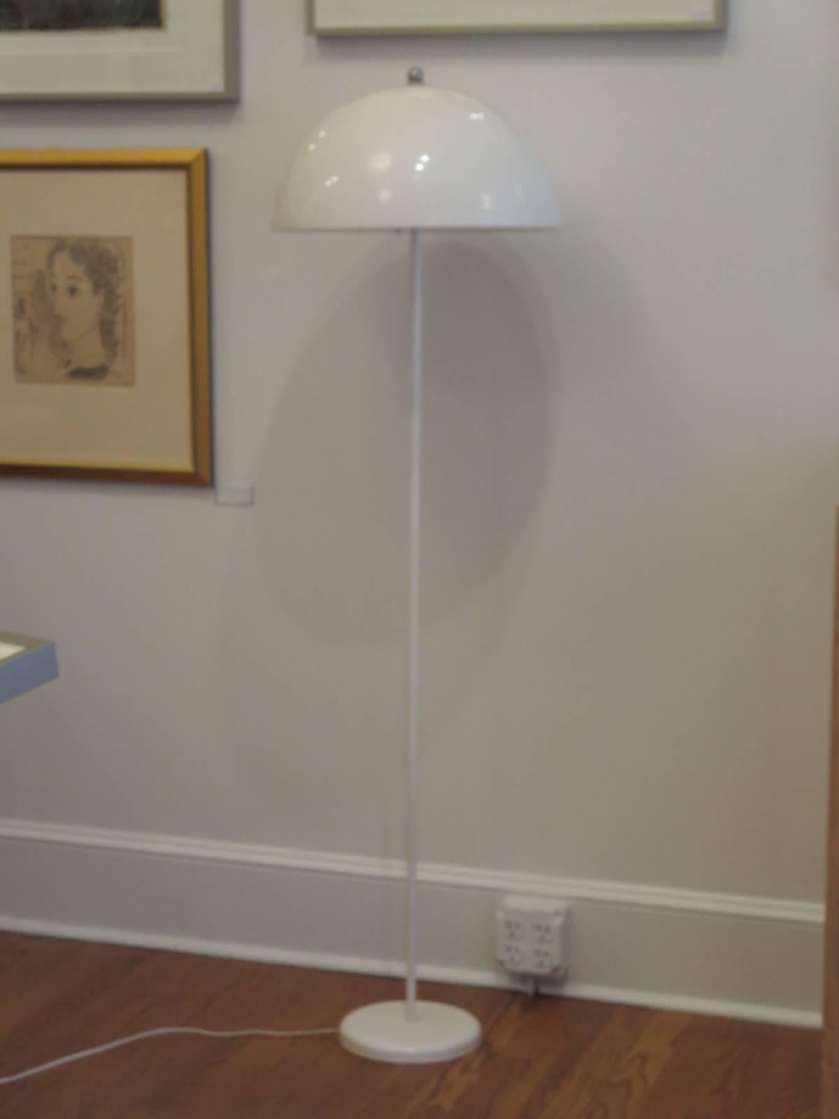 Floor lamp with a soft white color shade on a metal stand.