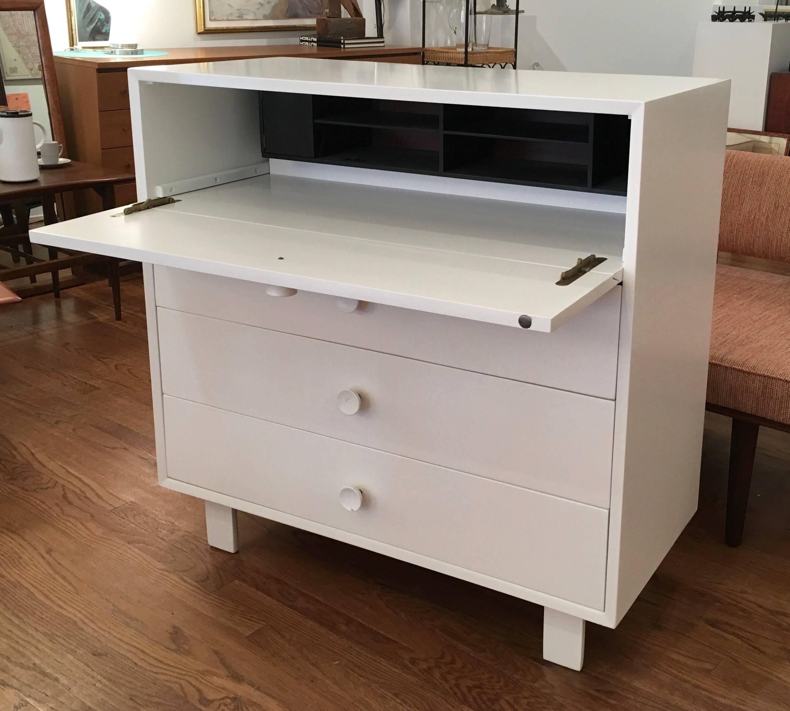 Iconic George Nelson dresser which also functions as a desk designed for Herman a Miller. Label inside drawer. Recently refinished in white lacquer. Deep set black organizer inside.