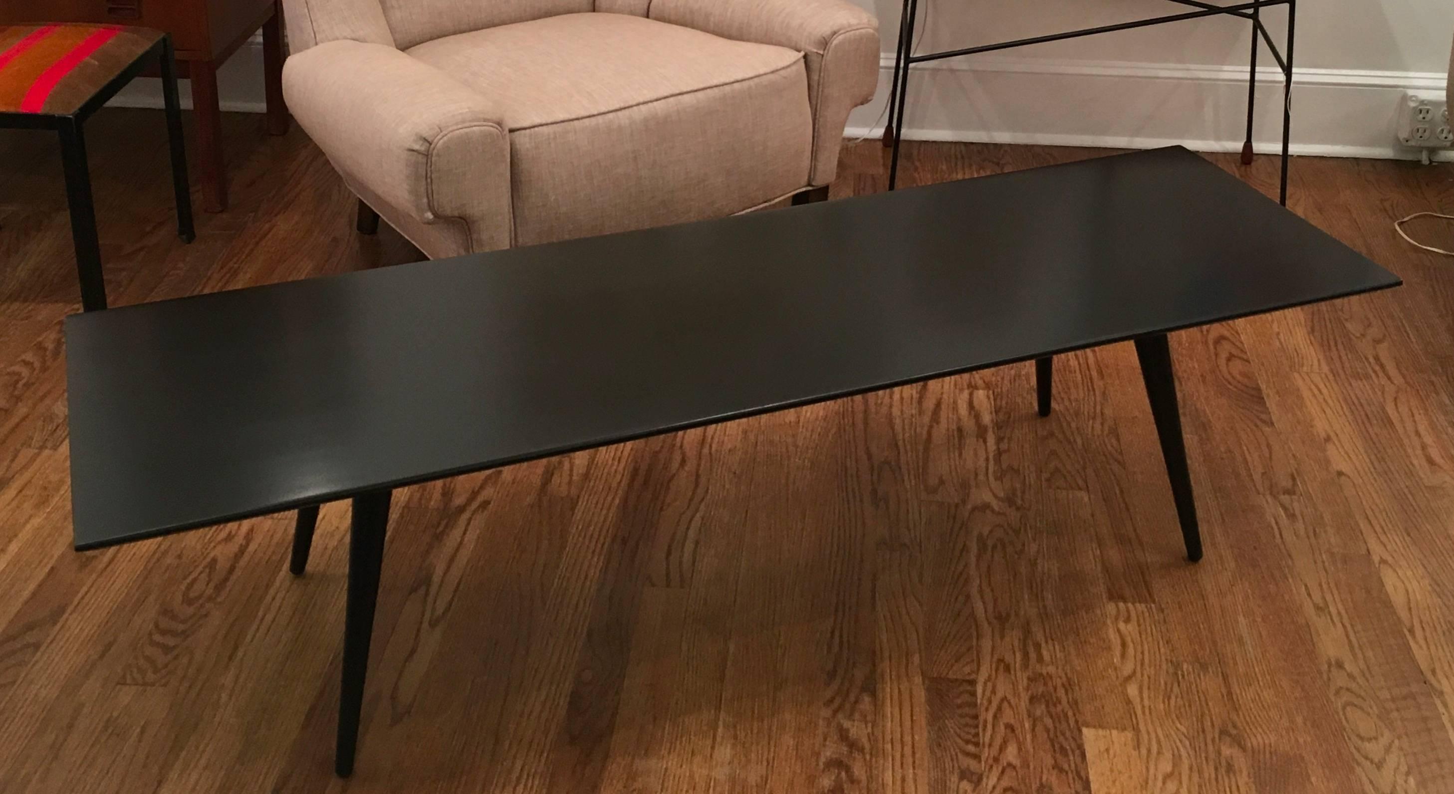 This iconic coffee table was designed by Paul McCobb as part of his Planner Group series. The solid wood table has recently been refinished matching it's original semi gloss black finish.
