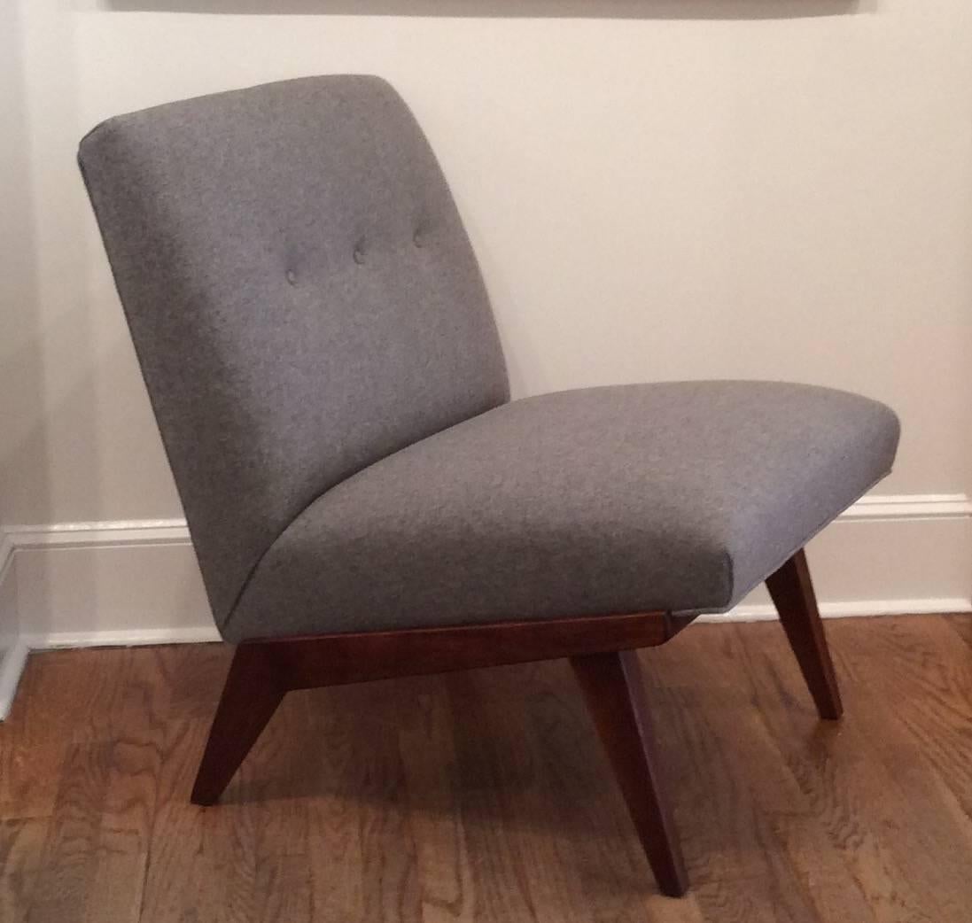 Original Jens Risom lounge chair designed for Knoll. Newly reupholstered in soft gray wool fabric. The floating base is walnut. The seat and back are both set at an angle which makes them very comfortable as well as easy to rise from.