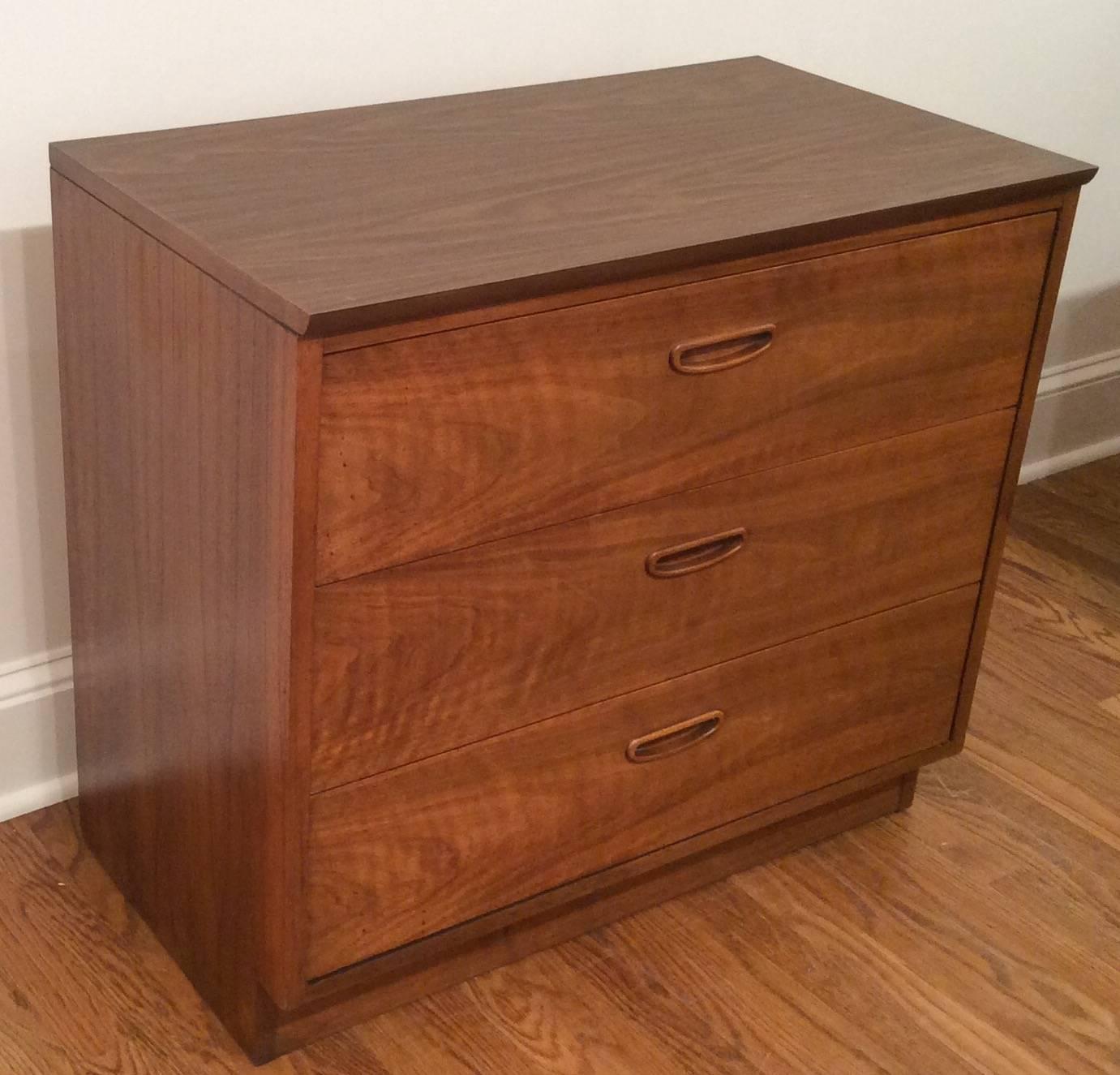 1960s three-drawer dresser by Lane. The dresser is a lovely walnut grain and the top is Formica. We have two available on our 1stdibs website. The drawer handles are recessed giving a modern appearance.