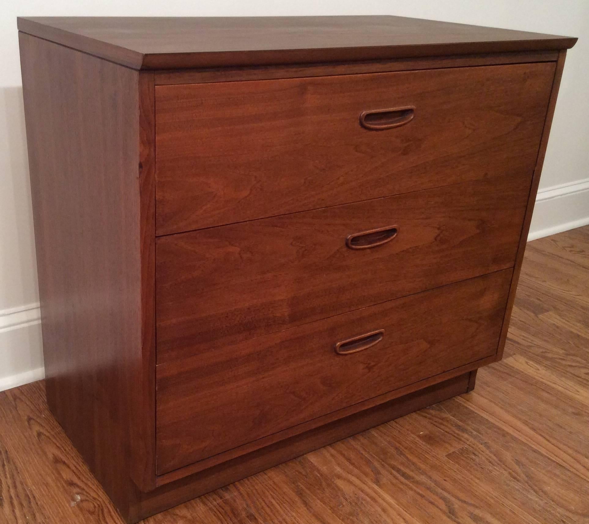 1960s three-drawer dresser by Lane. The wood grain is beautiful walnut and the top is Formica. The drawer handles are recessed and give the piece a modern appearance. Can be used as nightstands. We have two available and are listed separately on