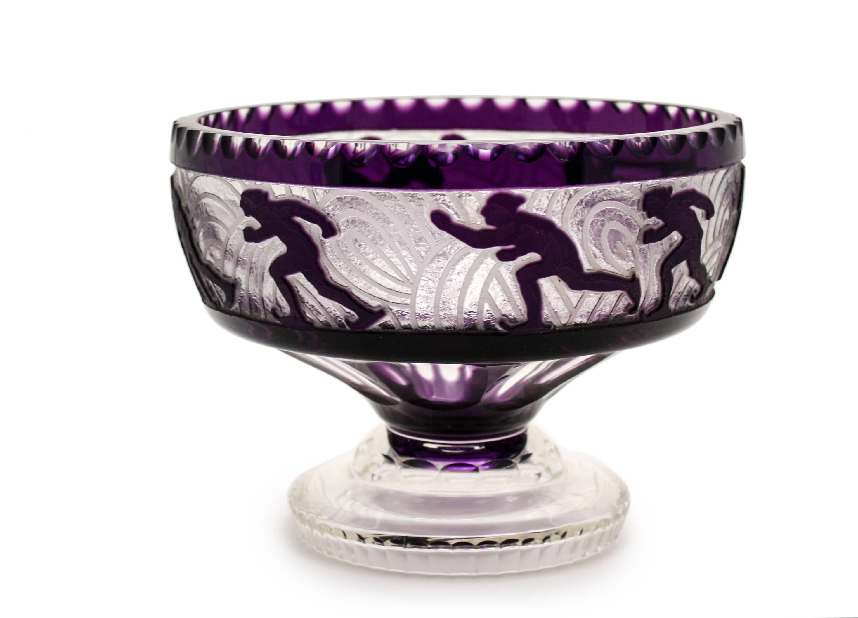 One of the more unusual pieces of Art Deco glass, this footed compote/centerpiece says it all. The thick blank is overlaid with amethyst crystal and cut to clear with a rare skating motif. Clearly designed with a winter motif, the entire perimeter