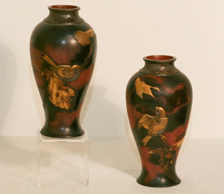 This beautifully paired set of Aesthetic Movement Japanese bronze vases are decorated all around the body featuring birds and foliage. The contrast of the copper and gold tones and naturalistic patination makes a dramatic statement, perfect of