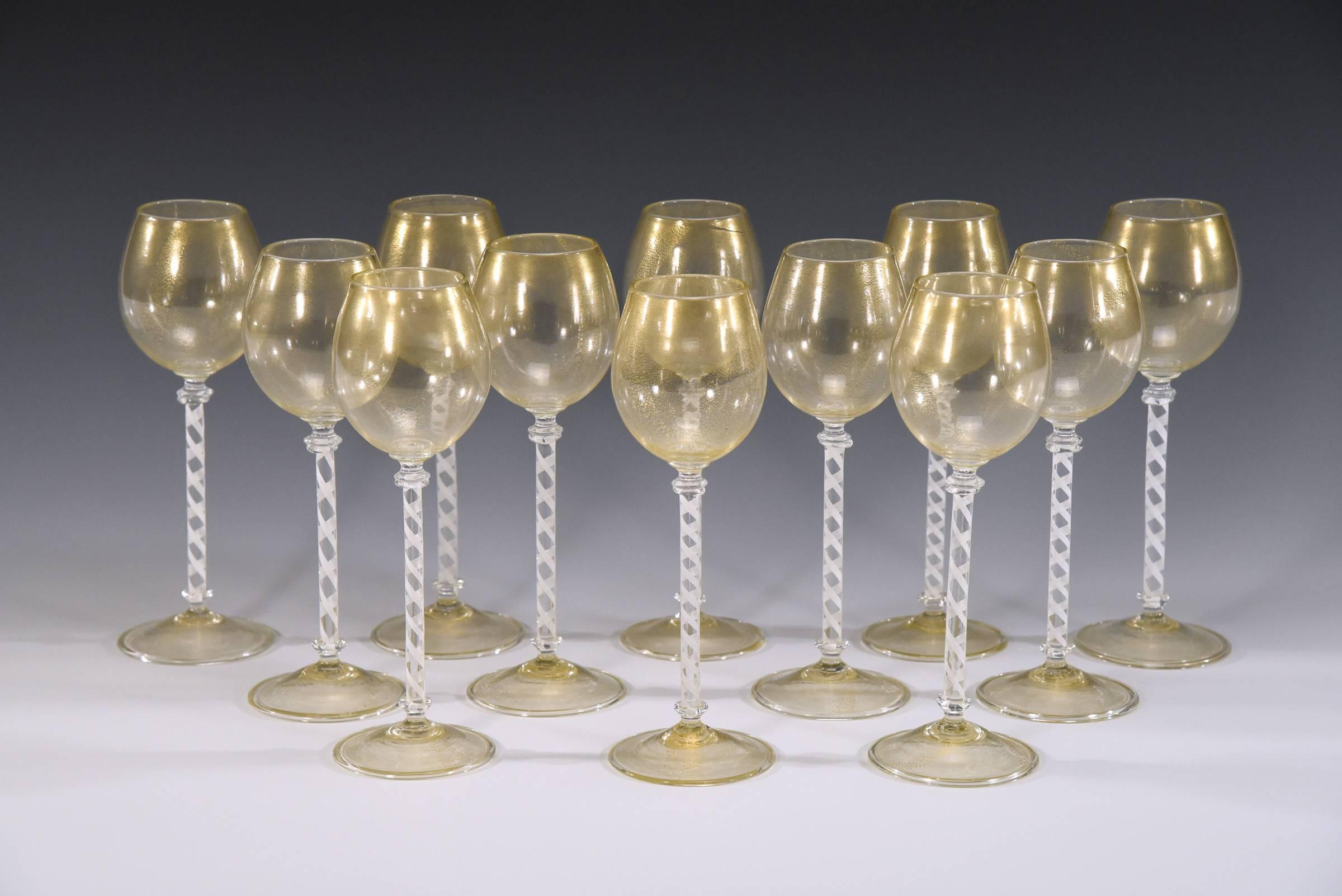 A lovely set of 12 hand blown tall and elegant wine goblets. The bowl and foot are embellished with gold leaf and the tall stems are composed of white twisted canes which are a subtle but dramatic contrast. These would work beautifully with many