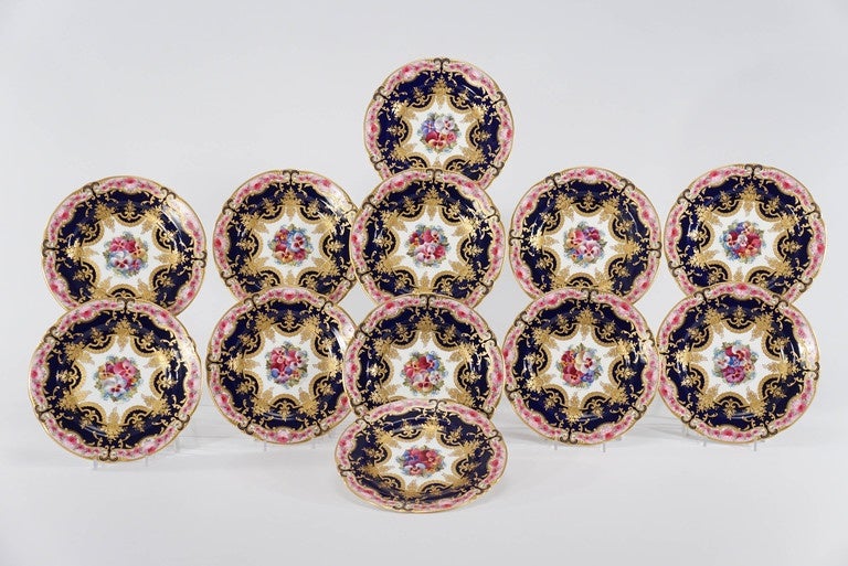 This set of 12 Cauldon/Brown Westhead and Moore dessert plates are decorated with the most elaborate and finely hand-painted botanical motifs. The cobalt blue ground frames the central pansy centers, all surrounded by roses embellishing the border