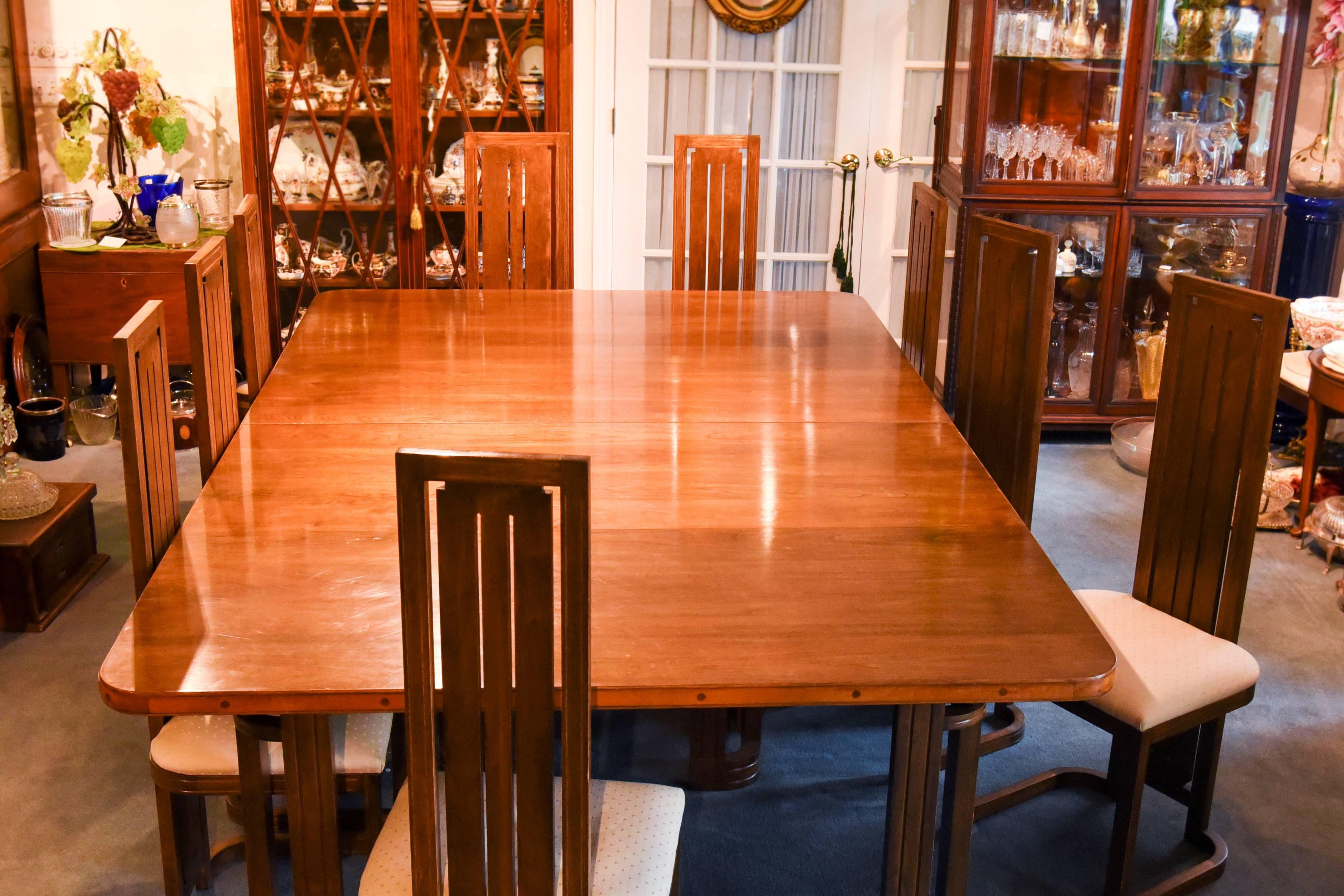 This is an amazing bench-made mahogany dining set with a large, exceptionally wide table and 12 matching chairs including 2 arm chairs and 10 side chairs. The workmanship is fabulous, detailed and iconic. The table is made up of fruitwoods and