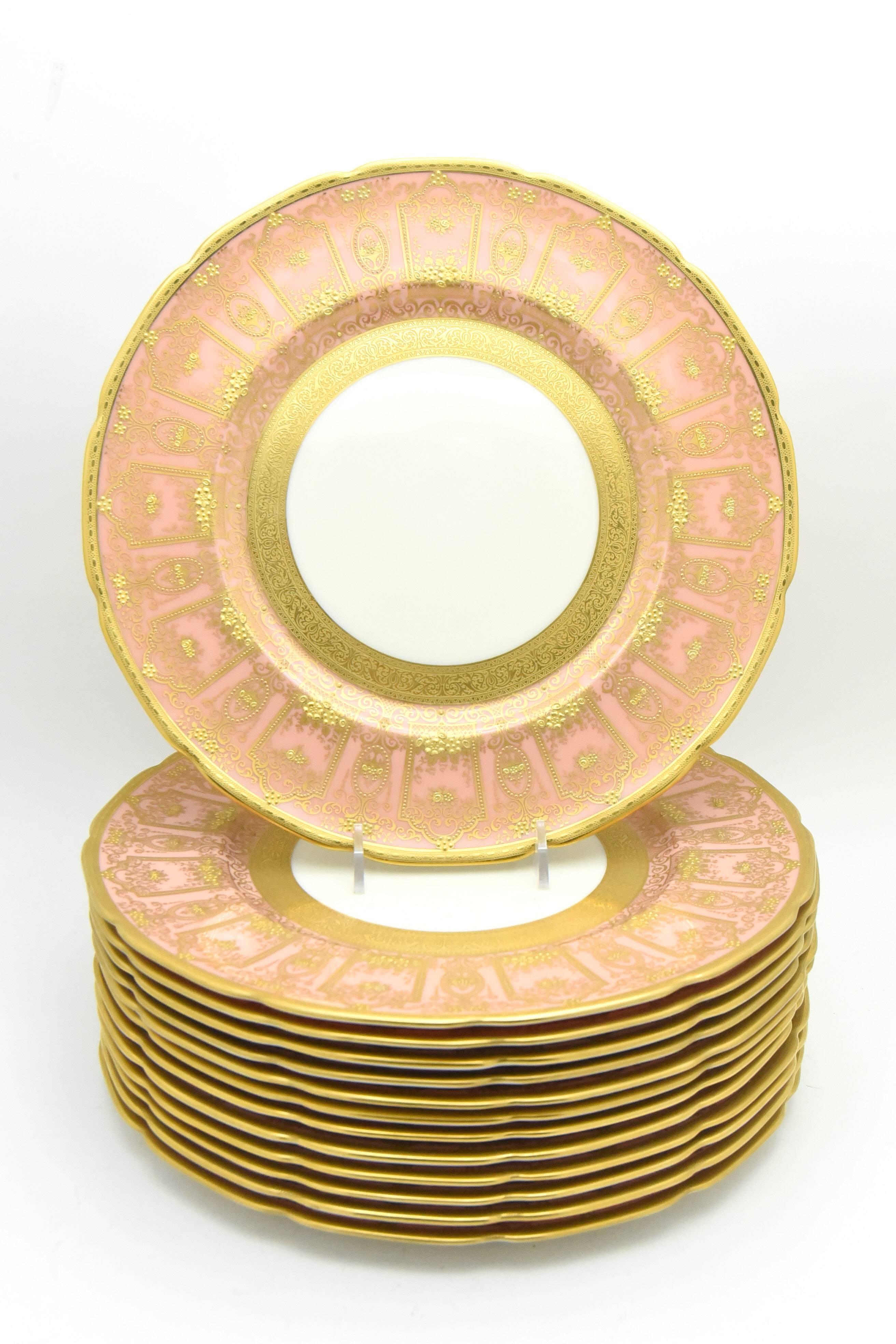 The set of 12 Lenox dinner plates feature a soft rose/pink border with shaped rims and elaborate acid-etched gold inner borders. The lavish raised paste gold neoclassical garlands and arches make an elegant statement. These are perfect as