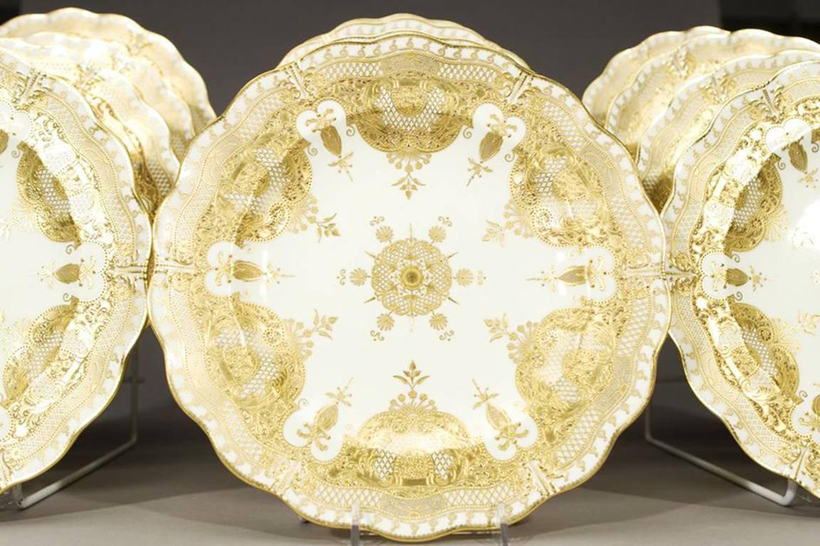This magnificent set of 12, 19th century Royal Crown Derby service, presentation plates are fit for royalty with the subtle contrast of ivory and two colors of raised paste gold. Even the backs of the plates are gilded, as are the foot rims.