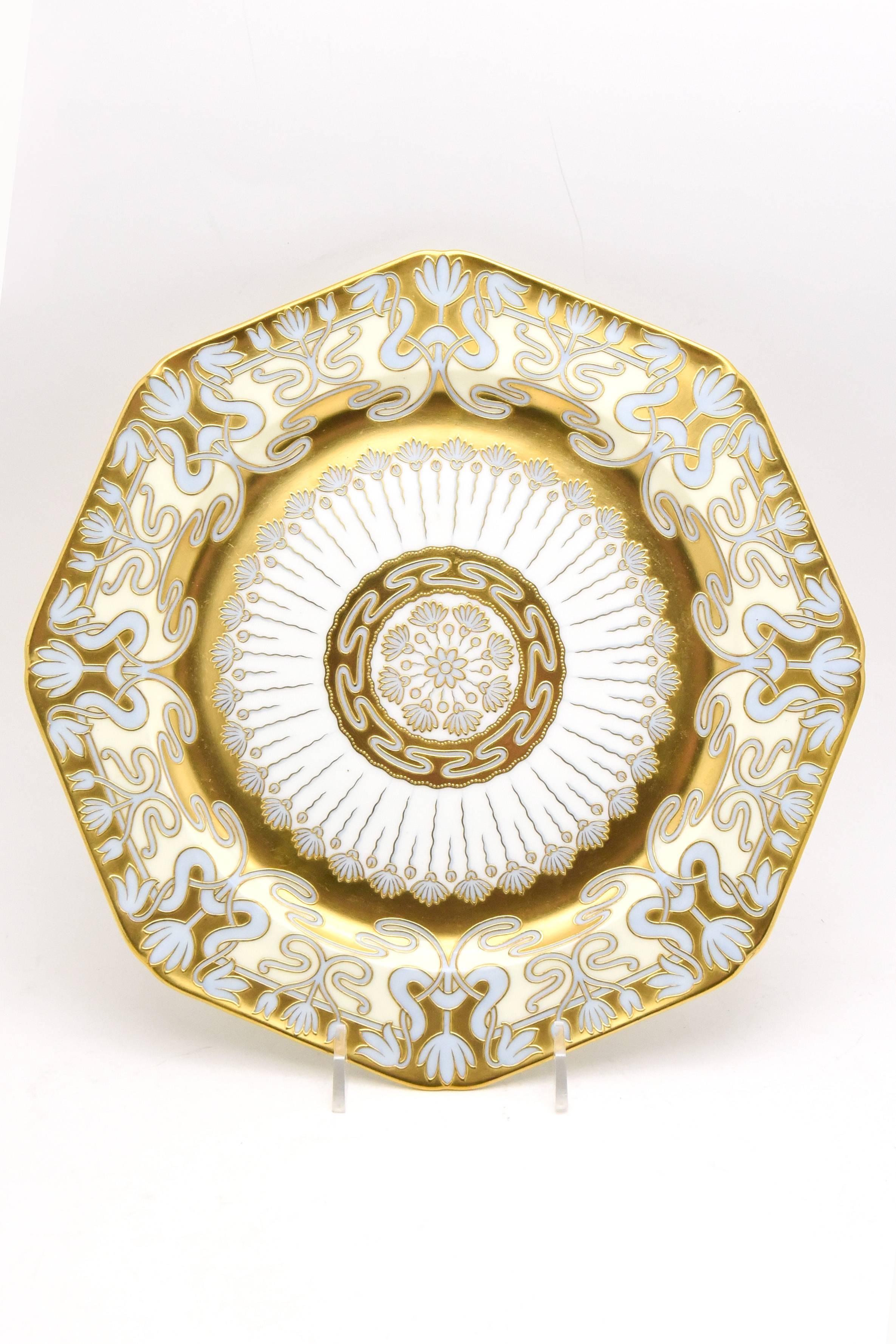 This is a very rare set of 12 Cauldon service/presentation plates showcasing Art Nouveau decoration at it's finest. Hand-painted raised paste gold over robin's egg blue creates a soft and elegant contrast to the flowing lines of the gold decoration.