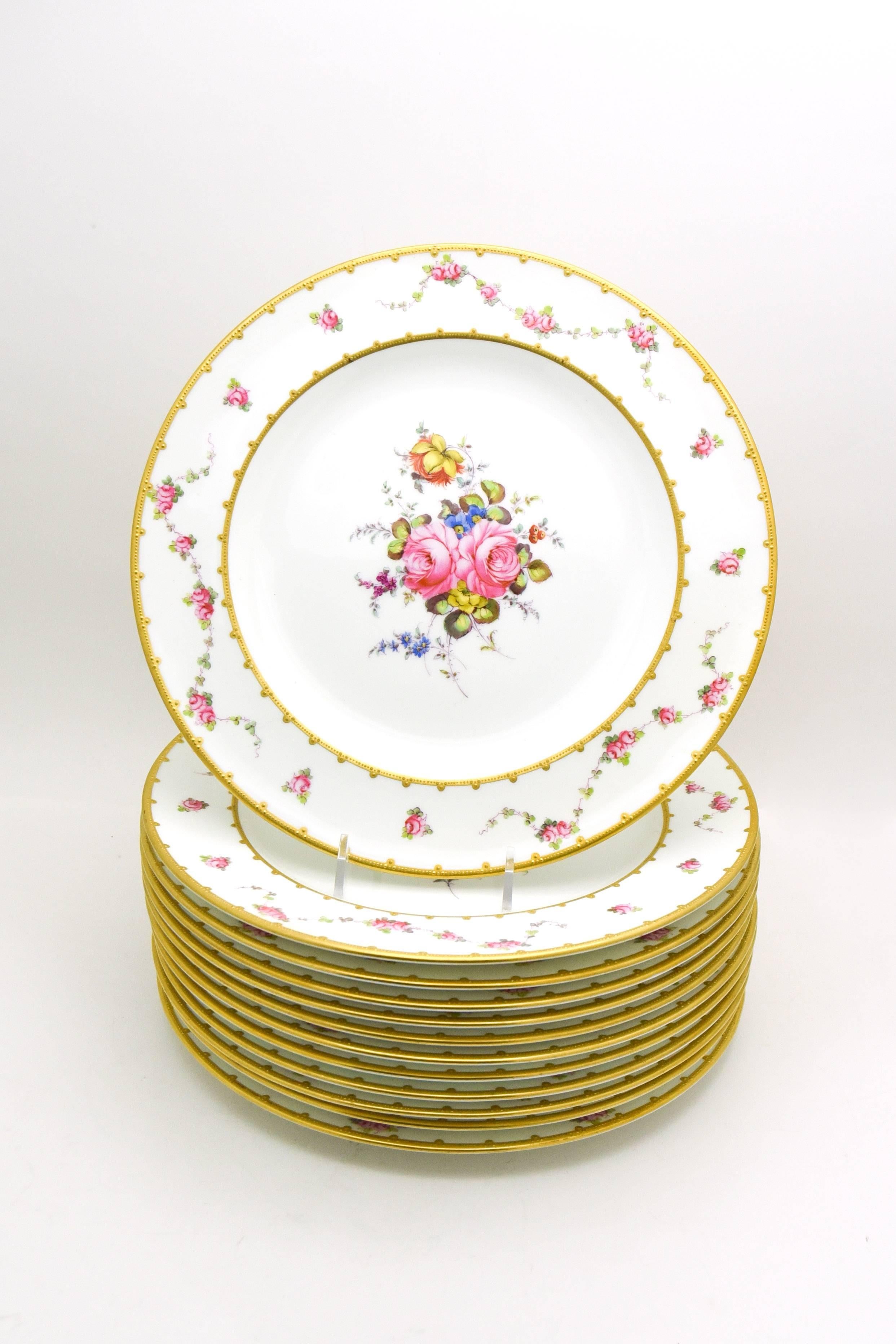 This set is a great example of the iconic artistry and style of Royal Crown Derby.
These plates are embellished with swags of vibrant hand-painted roses and two bands of acid etched gold with delicate raised paste 