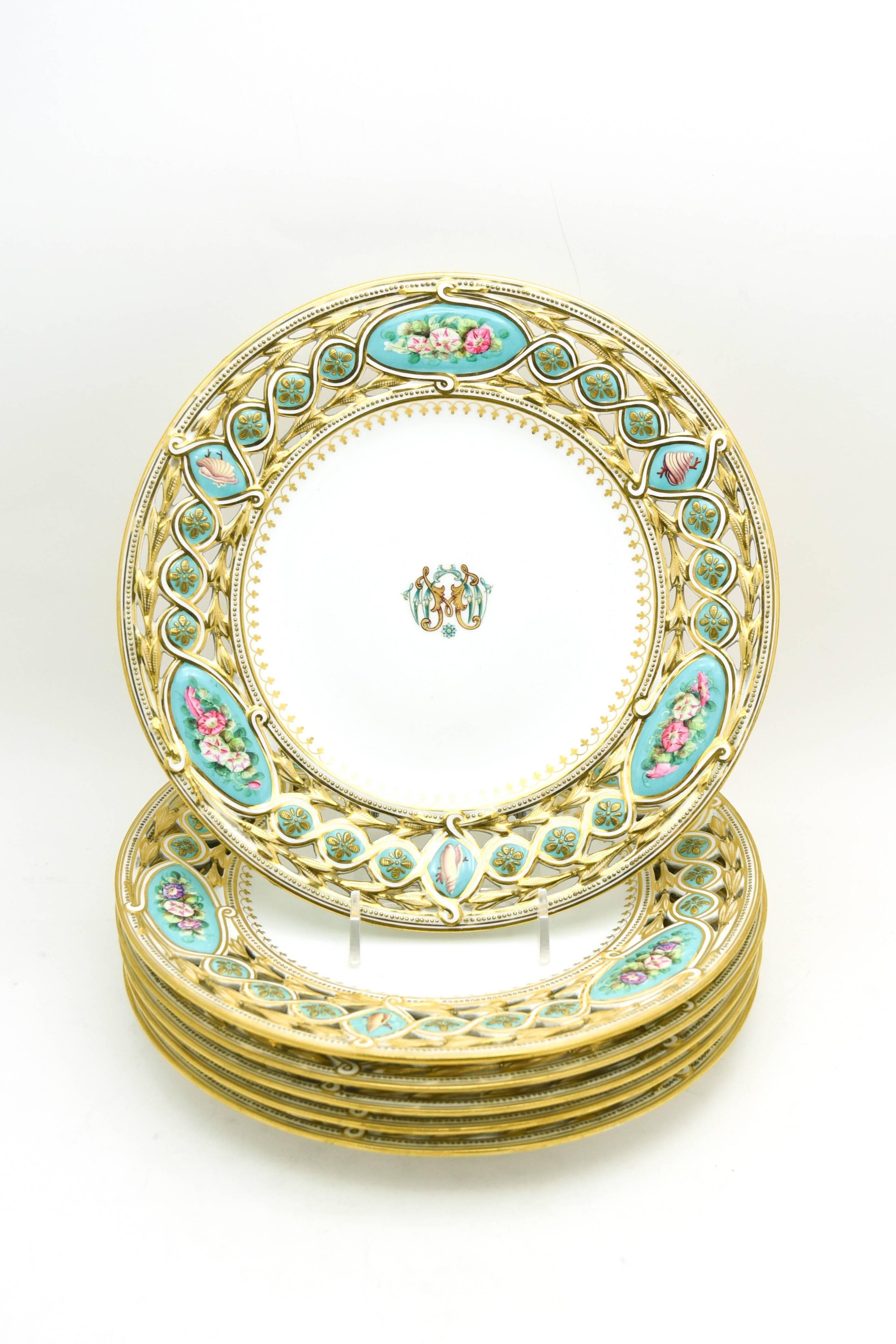This unusual dessert service consists of six plates and two matching footed compotes with amazingly intricate pierced borders. Each piece is uniquely hand painted with flowers and shells and embellished in gold. The reserves are painted with a soft