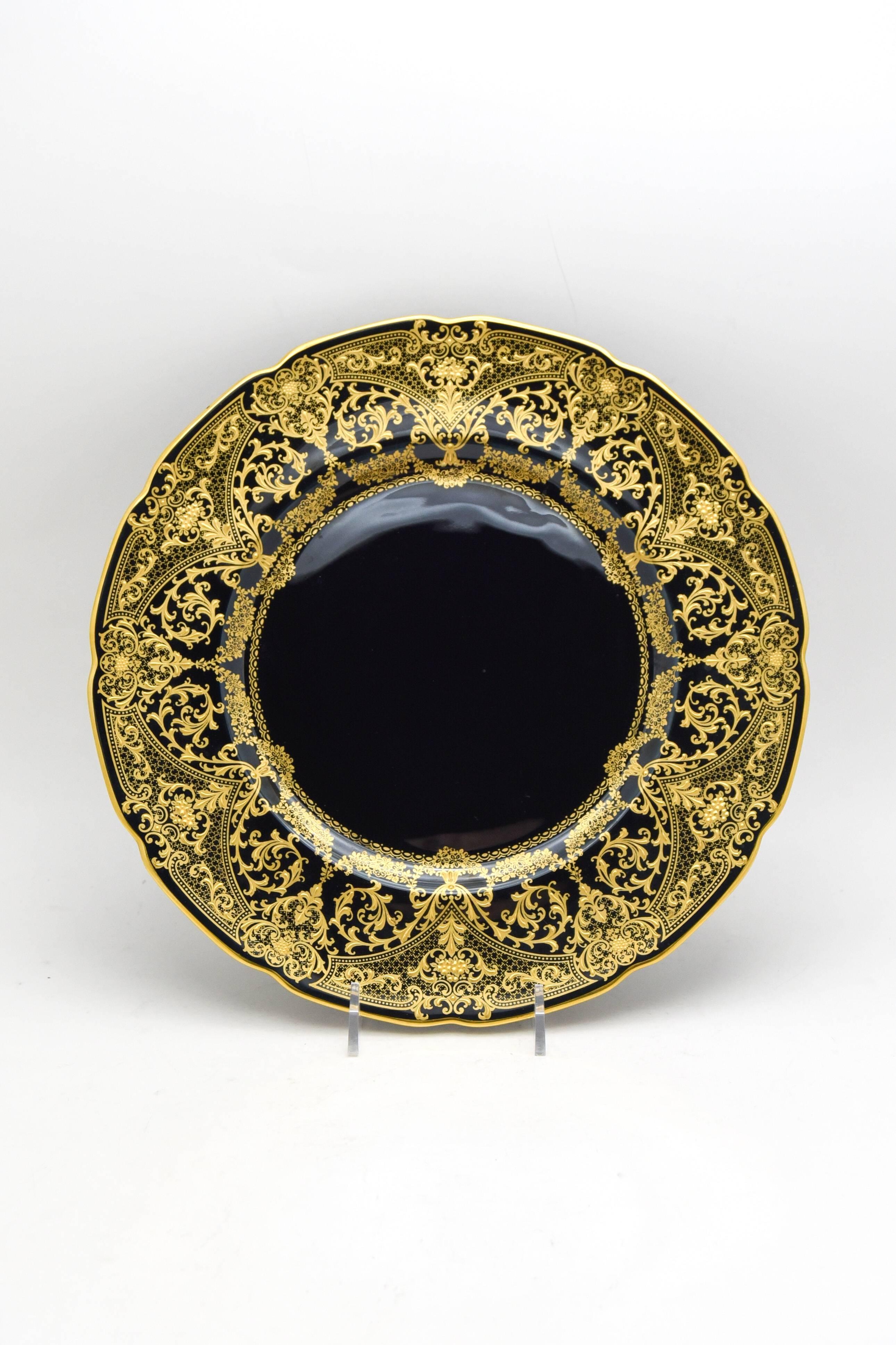 It is unusual to find dinner or service plates with a true black enamel ground and this set is a rare example. Not only the front, but the entire plate is decorated with black enamel ground creating a dramatic contrast to the exquisite raised paste