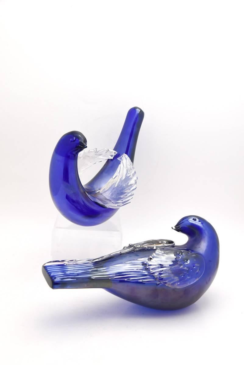 Designed by Tyra Lundgren circa 1930s, this signed pair of whimsical full sized doves was made by Venini in Murano, Italy. The pair are well proportioned, each one unique in design in complementary poses. The rich blue bodies are completed by