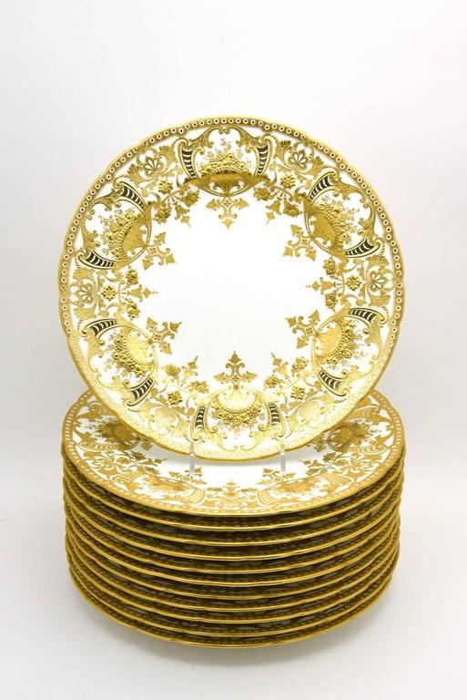 There is great and then there is magnificent and these plates made by Royal Crown Derby qualify as magnificent! This set of 12 dinner plates exhibit all of the characteristics of the finest gilt decoration with profuse raised paste gold surrounding