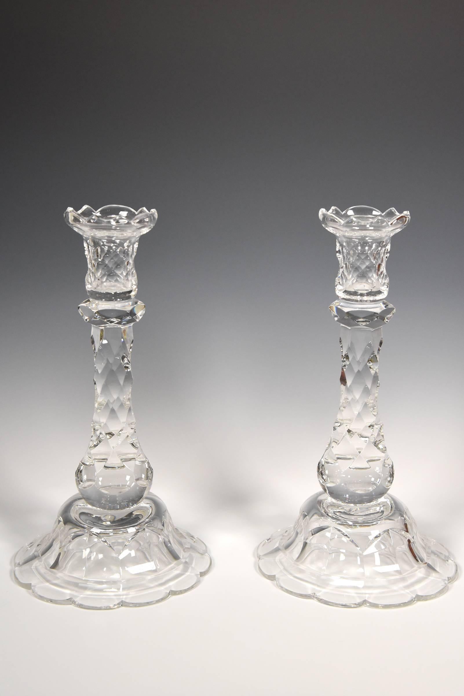 Two pairs of candlesticks offer a versatile grouping and these four matching hand blown crystal candlesticks are perfect examples. Made in England by Stuart Glassworks, they are cut in an early 19th century honeycomb pattern with a conical base and