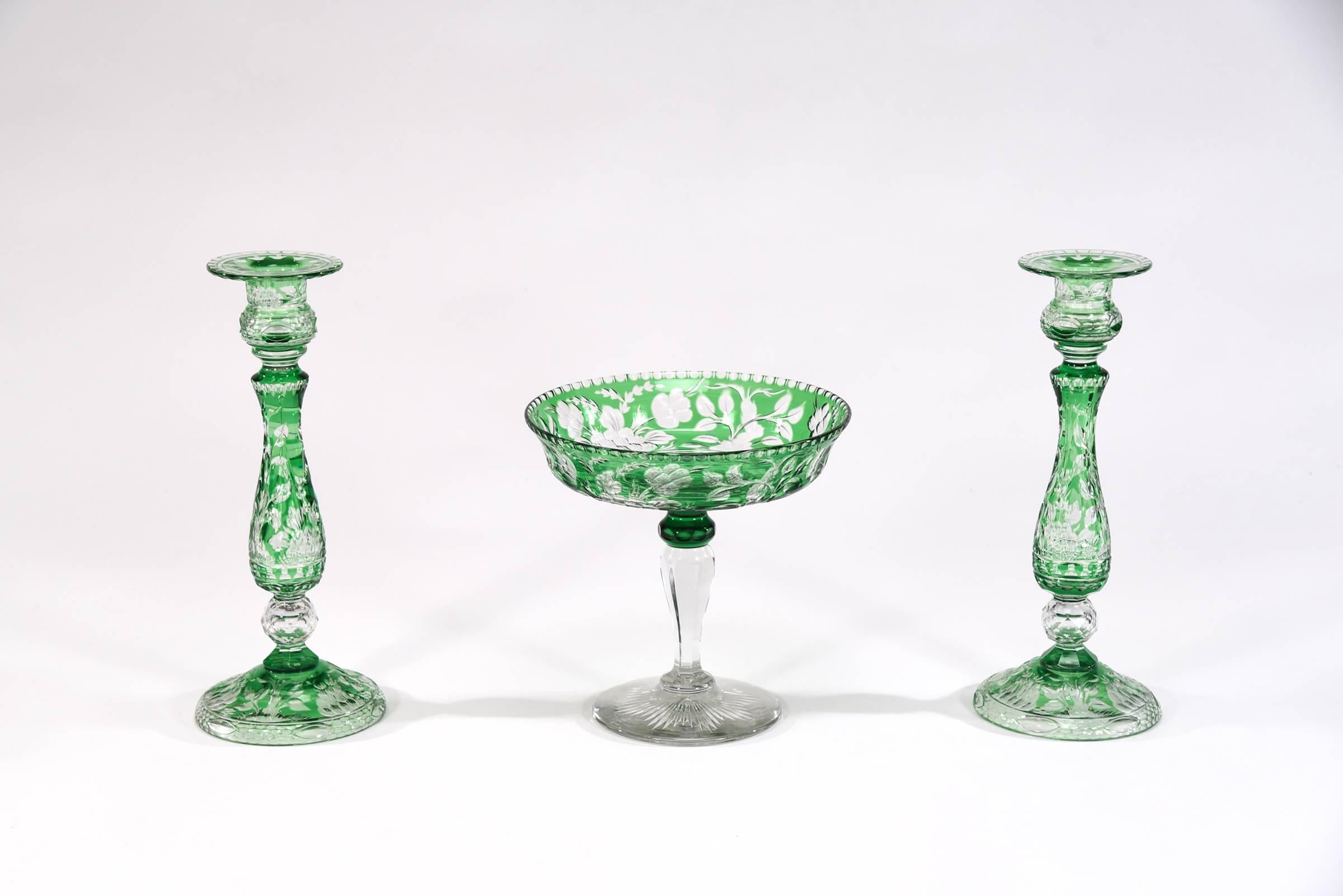 This is an extremely rare and complete Stevens and Williams handblown crystal centrepiece set. It features a pair of matched handblown candlesticks with emerald green overlay and intricately cut to clear in one of their iconic floral Art Nouveau
