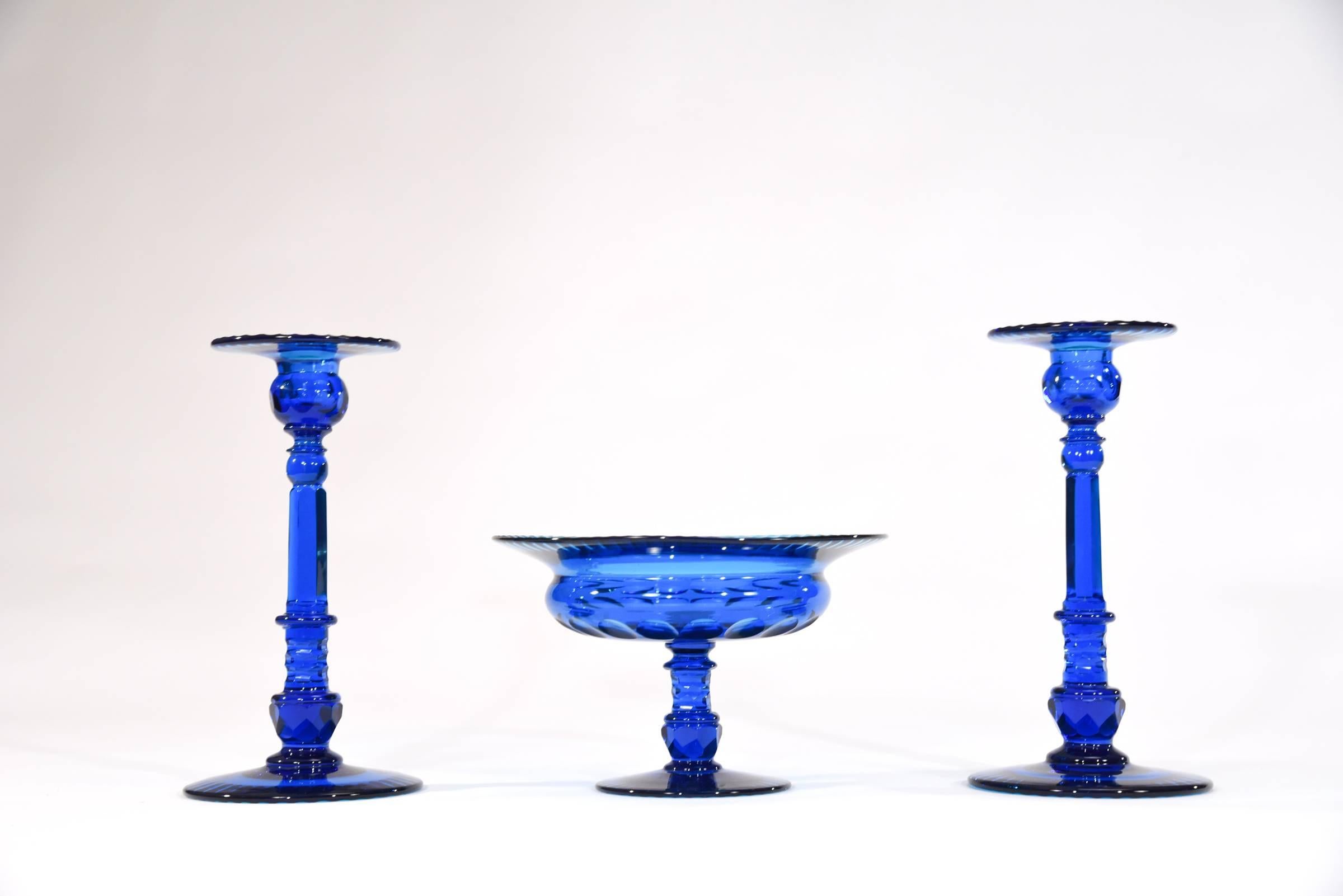 This is a dramatic and large centerpiece set made by Steuben in their heyday. The rich deep turquoise blue is the perfect focal point on a table, sideboard or in a treasured collection. Each piece is handblown crystal that is masterfully cut with