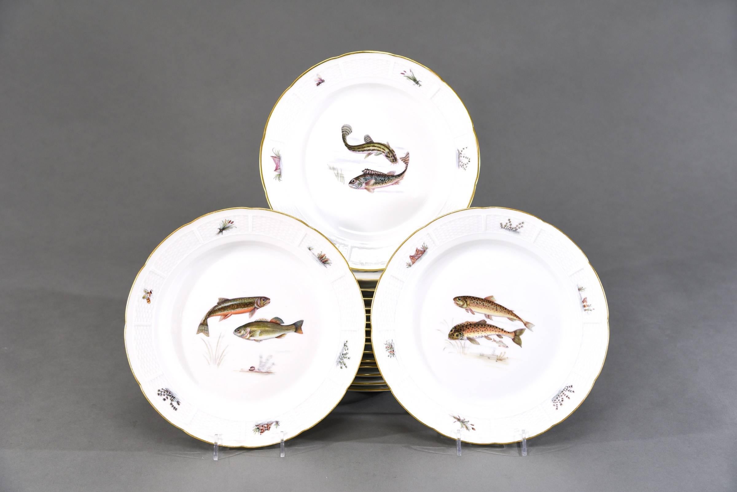 This is a complete set of full size fish plates and matching bowls and large platter. The molded basket weave borders are decorated with marine life motifs including reeds, seaweed and dragonflies. Each plate has the name of the fish on the reverse