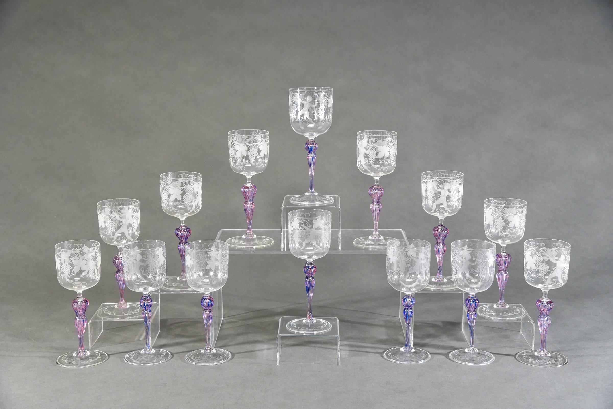 This is a set of 14 handblown goblets made in Venice, featuring a combination of a clear bowl with engraved decoration sitting on top of contrasting amethyst stems. What makes these so impressive is the variation in color due to the combination of