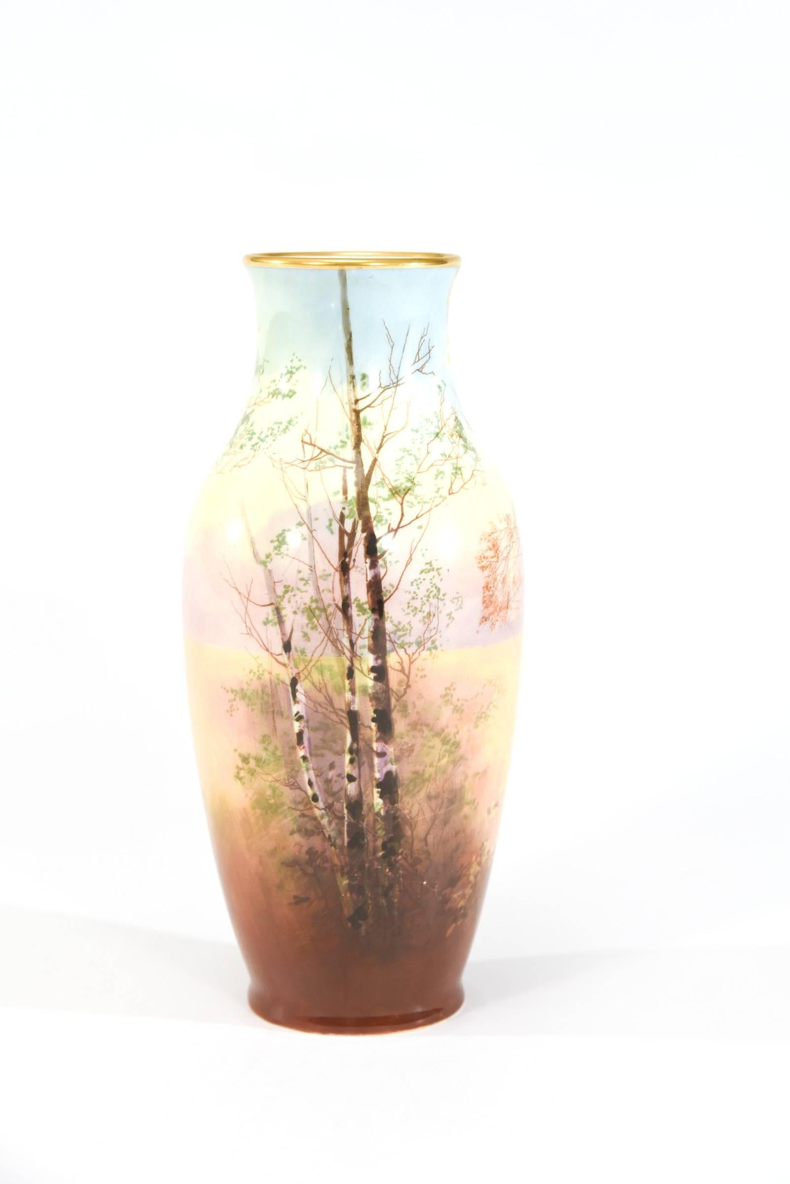 This finely decorated porcelain vase was made by Royal Doulton and is hand painted and artist signed J. Price. He was known for his beautiful landscapes and this vase is decorated on the entire circumference. Featuring a stand of silver birch trees