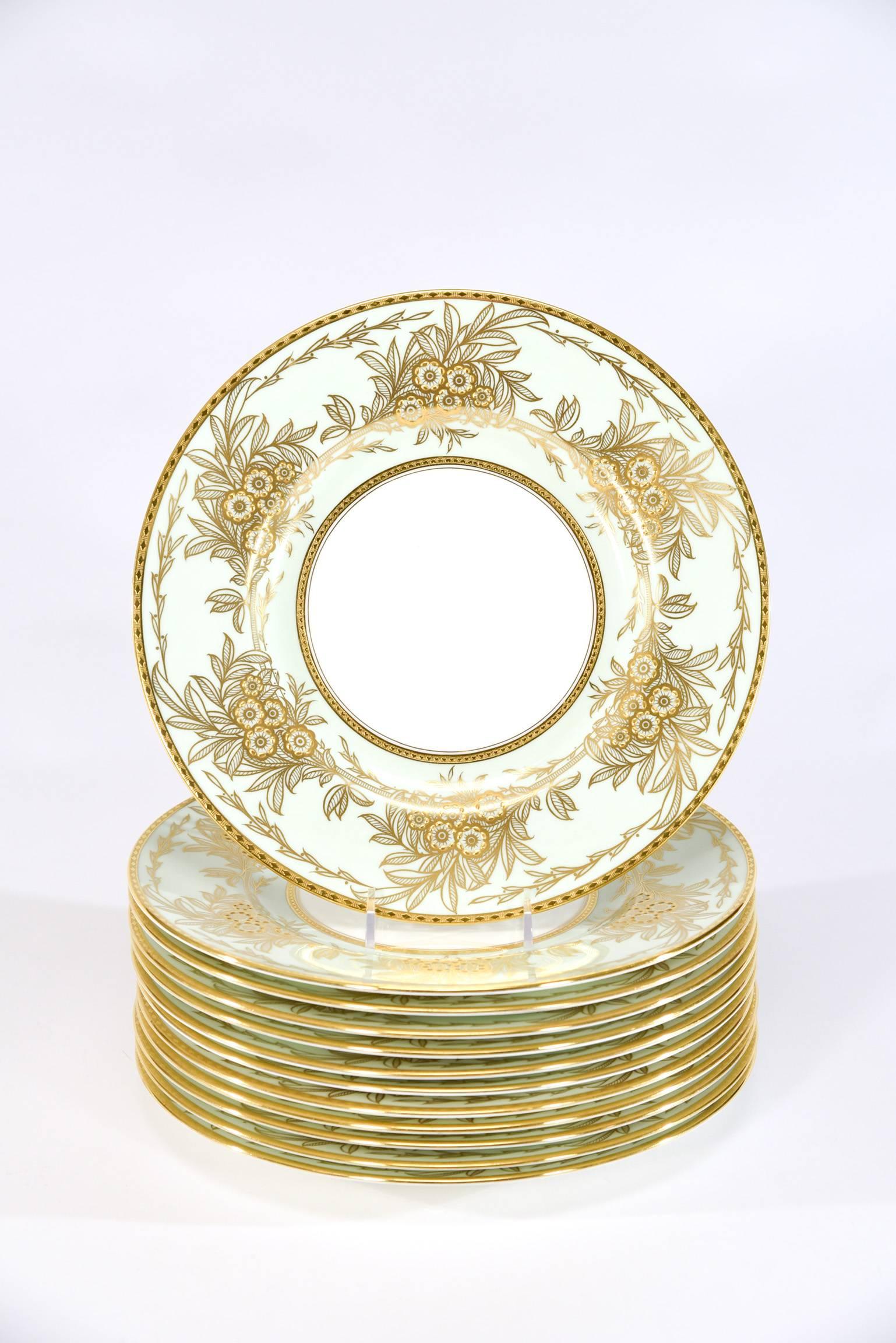 This set of 13 Minton dinner plates feature the iconic "Eau de Nils" enamel border which is a soft blue green, described as the "water of the Nile". The clean white centres are framed with a lovely raised paste gold floral Arts