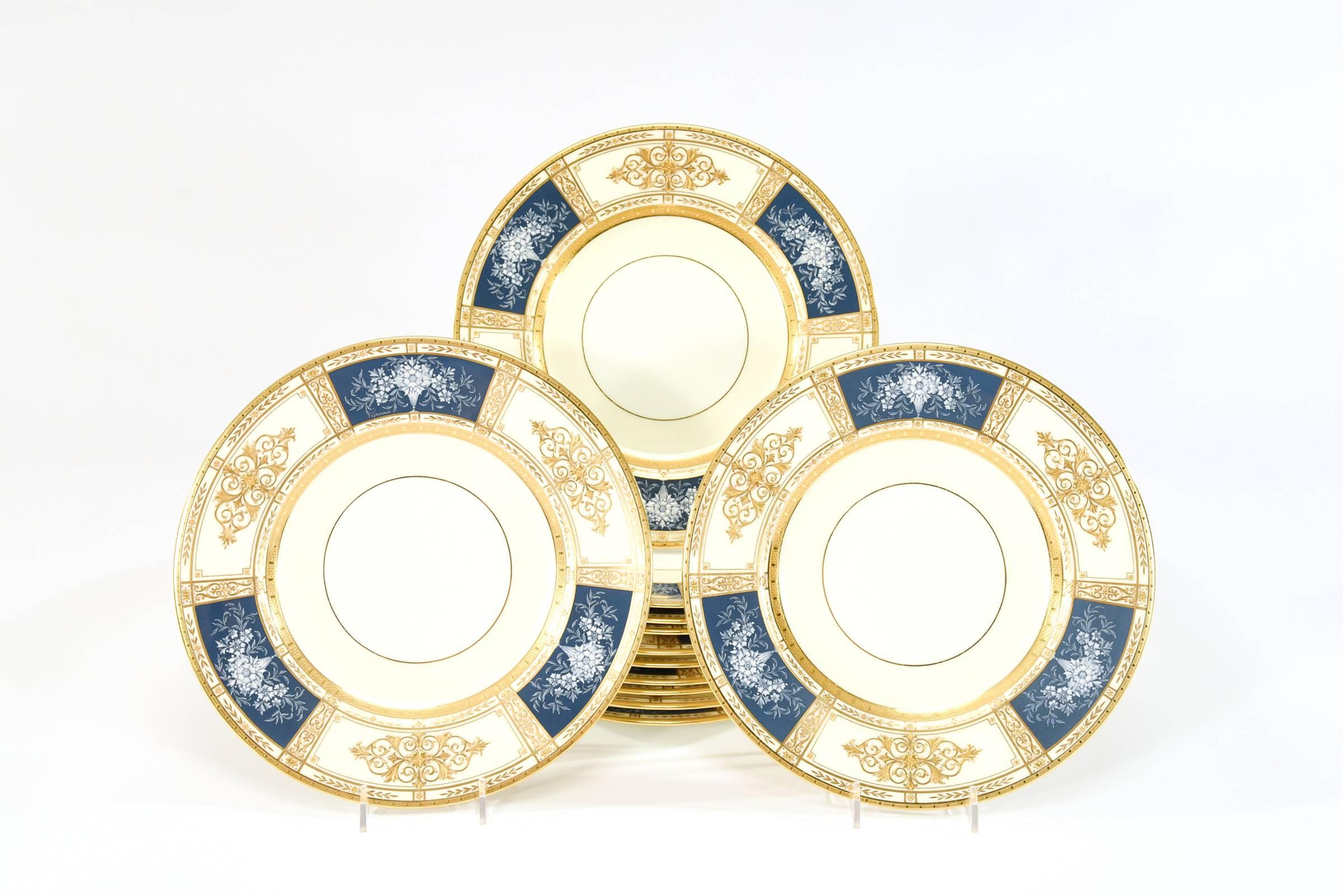This set of 12 Minton dinner plates exhibits the beauty and quality of Minton's top of the line offerings. The acid etched gold border frames the three neoclassical reserves of raised paste gold and beading alternating with three blue reserves