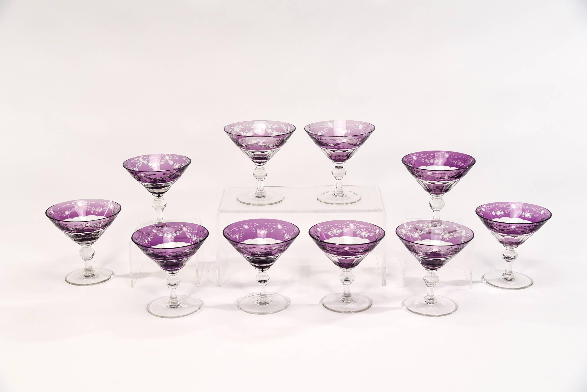 Ready for a pop of color, this rare set of ten handblown goblets are perfect for your favorite drink or even can be used as dessert coupes. The rich amethyst overlay border is cut to clear in an elegant floral pattern over the panel cut bowl and
