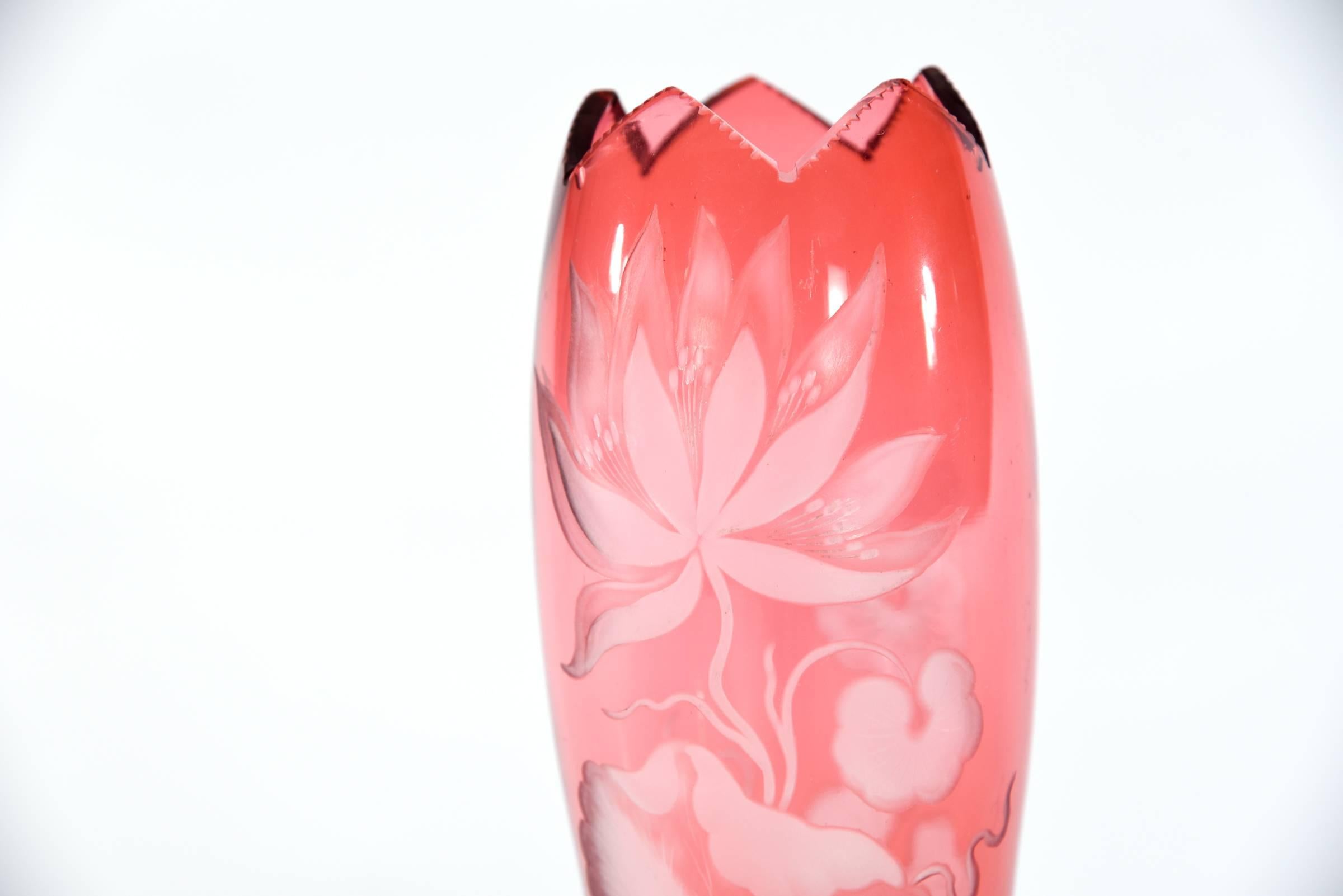 This handblown crystal vase was made by Webb, England and features cranberry overlay, cut to clear in the iconic Art Nouveau water lily motif. The tall and elegant shape is topped off with a six-pointed opening and a star-cut foot. It is decorated