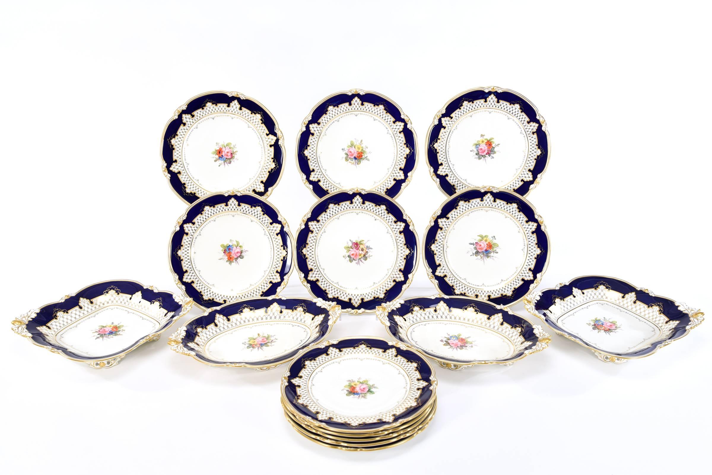 Ce service à dessert Royal Crown Derby de 15 pièces comprend 11 assiettes de 9 pouces, deux bols carrés et deux pièces de service à pied en forme de losange, qui sont classiques et polyvalentes. Chaque pièce est peinte à la main de bouquets floraux
