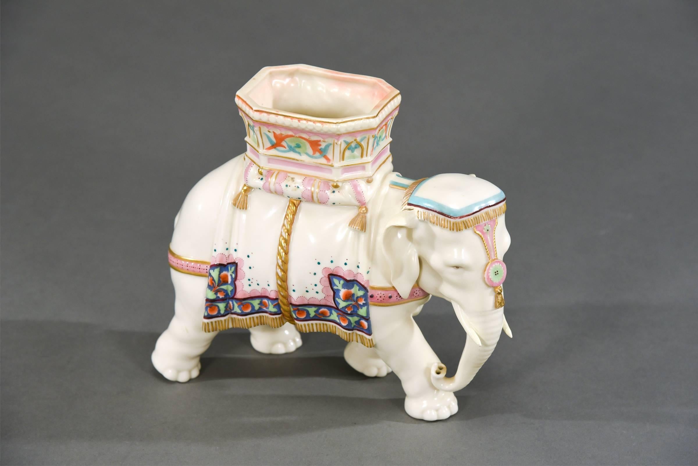 This is a charming 19th century English figural vase of an Indian elephant wearing a ceremonial howdah and head dress. Modelled by Royal Worcester's chief modeller, James Hadley, it is hand-painted in polychrome enamels and highlighted in gold.