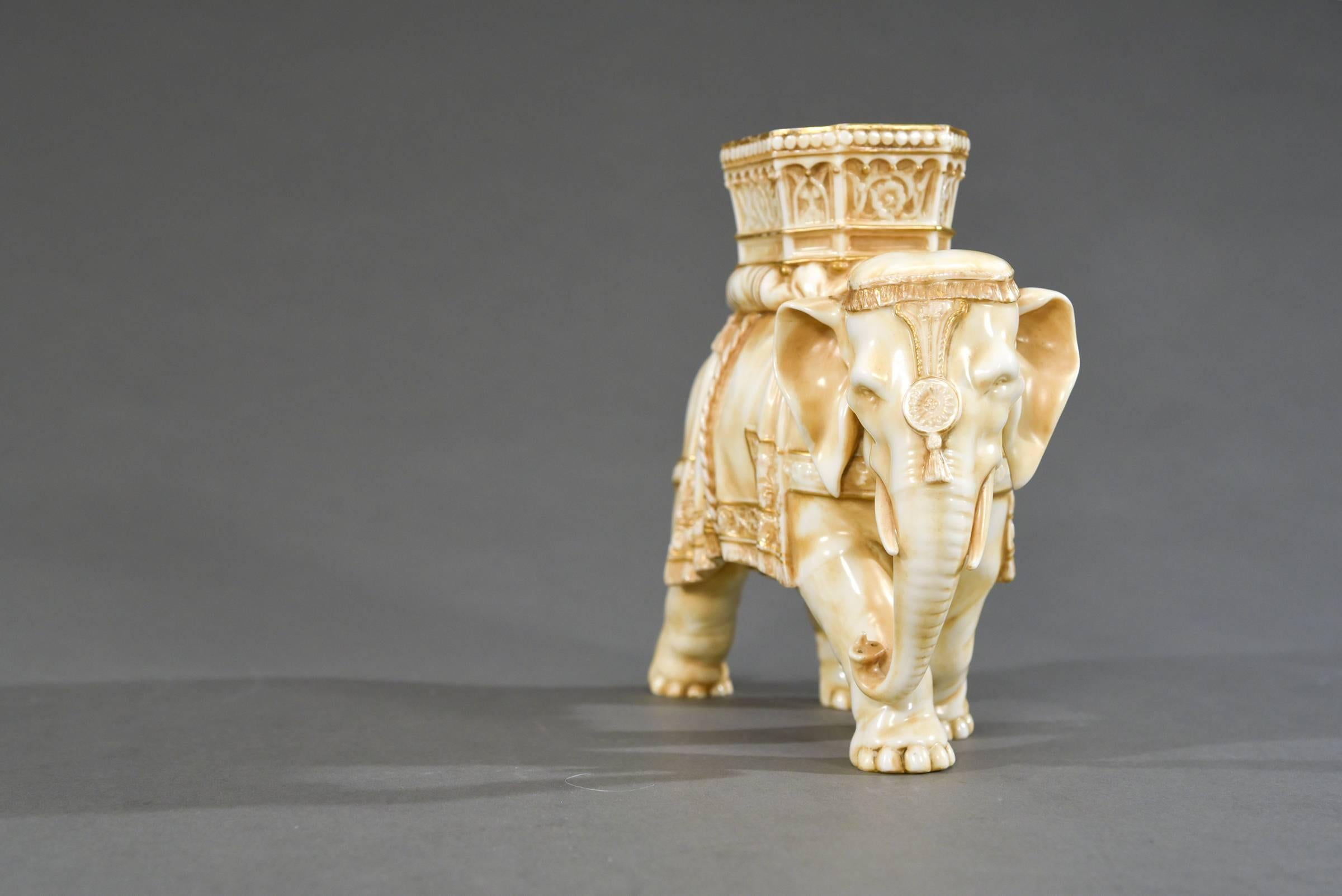 This is a charming 19th century English figural vase of an Indian elephant wearing a ceremonial howdah and head dress. Modelled by Royal Worcester's chief modeller, James Hadley, it is hand-painted in ivory and highlighted in gold. Marked with the