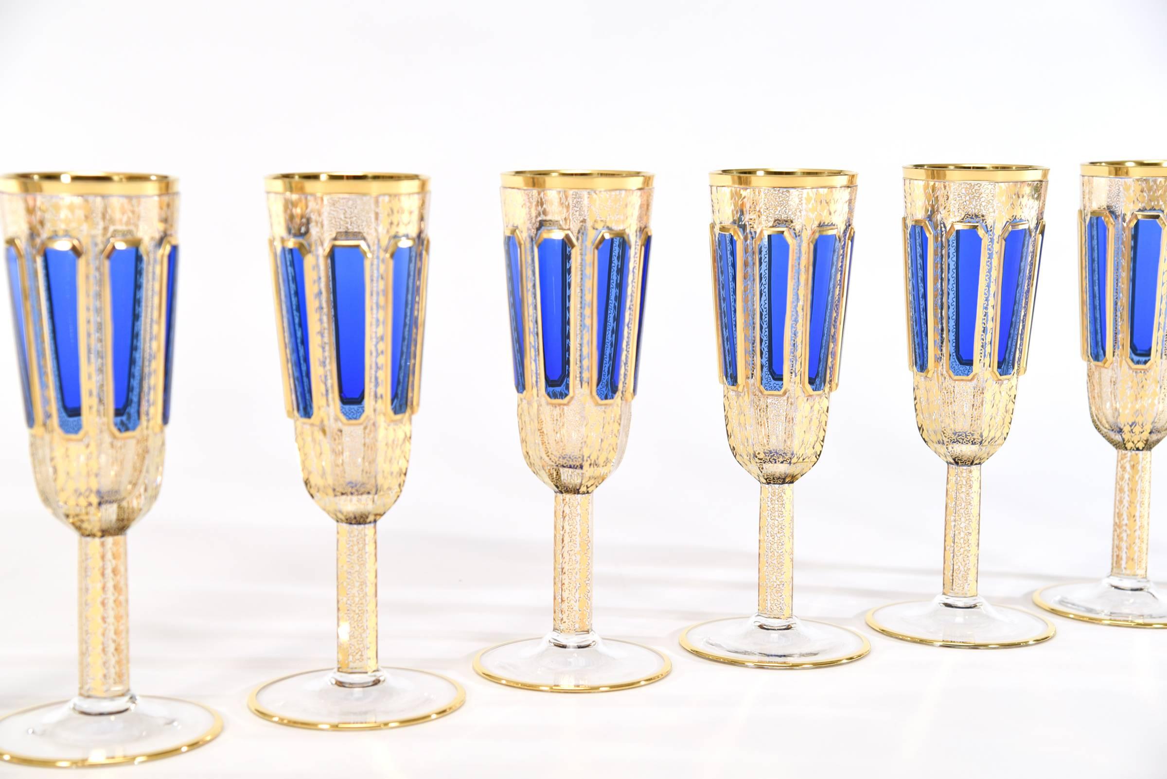This set of eight Bohemian handblown crystal champagne flutes are quite rare and in a sought after size. Part of a larger matching set of goblets, made by Moser, they feature elongated raised panels of rich sapphire blue 