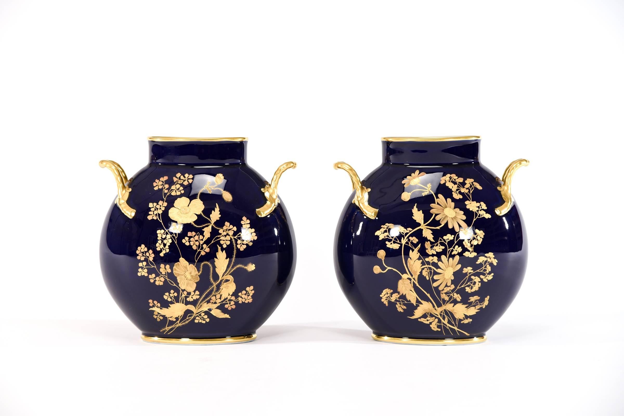 This pair of French porcelain pillow vases are the perfect answer to decorating a narrow space, such as mantlepiece. The deep cobalt blue ground creates a wonderful contrast to the Aesthetic Movement hand painted floral raised gold and platinum