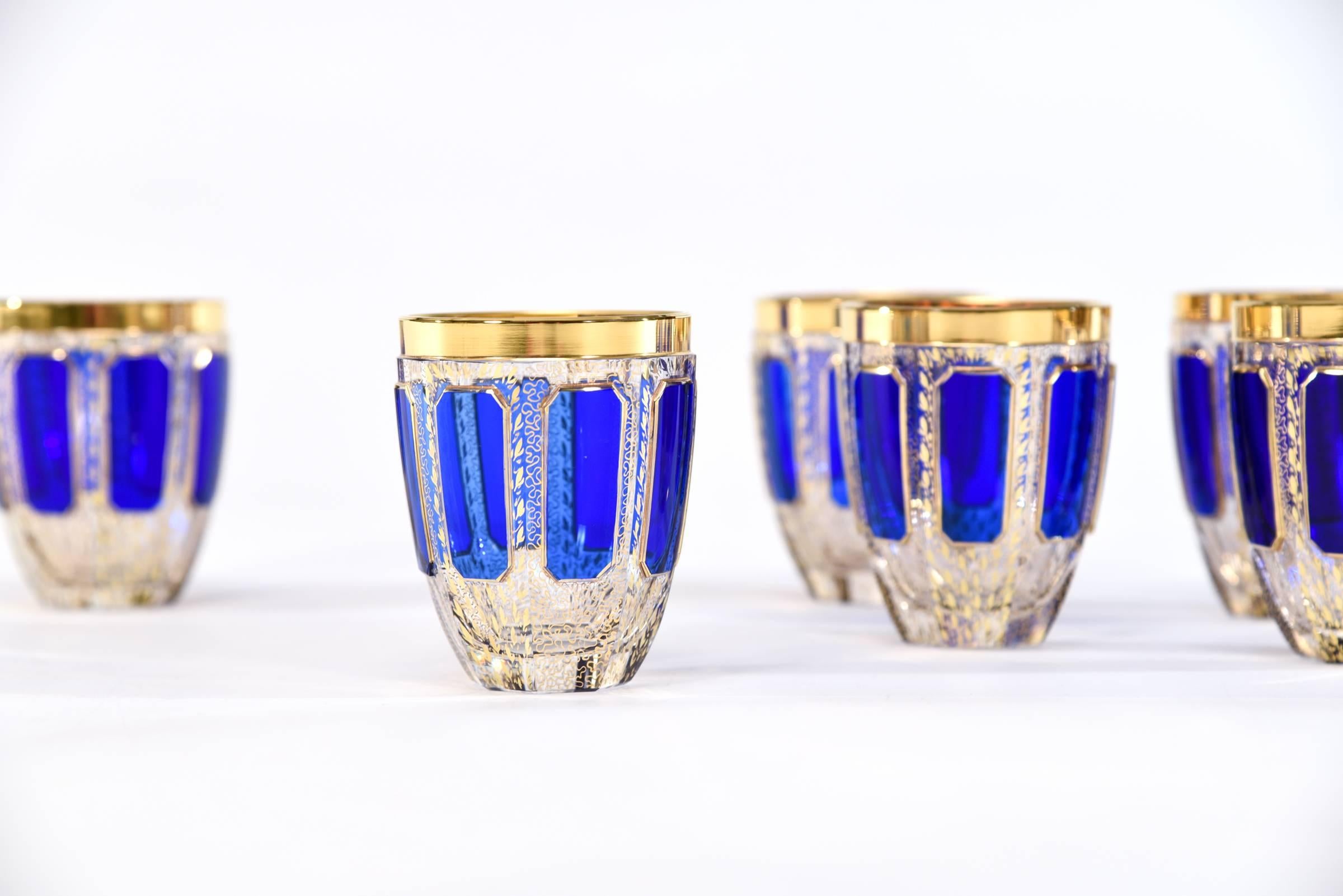 This set of eight Bohemian handblown crystal highballs with rounded base are part of a larger matching set of goblets, made by Moser. The unusual round shape feels wonderful to hold with their elongated raised panels of rich sapphire blue 