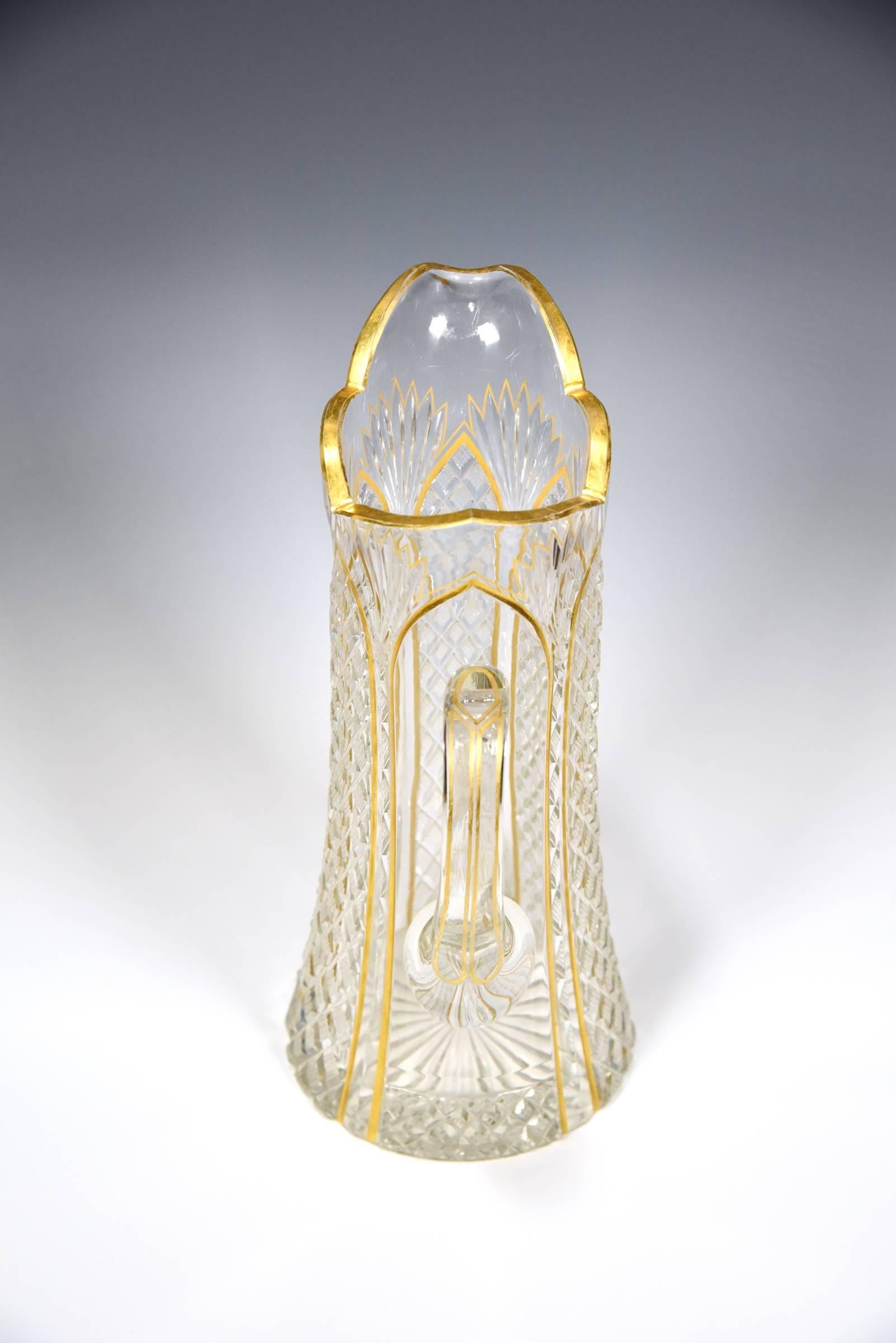 This is a stunning 19th century handblown crystal pitcher, attributed to Baccarat, which features all-over cutting and further embellished by finely enameled gilt decoration. The workmanship is extremely well-done and the geometric cutting is