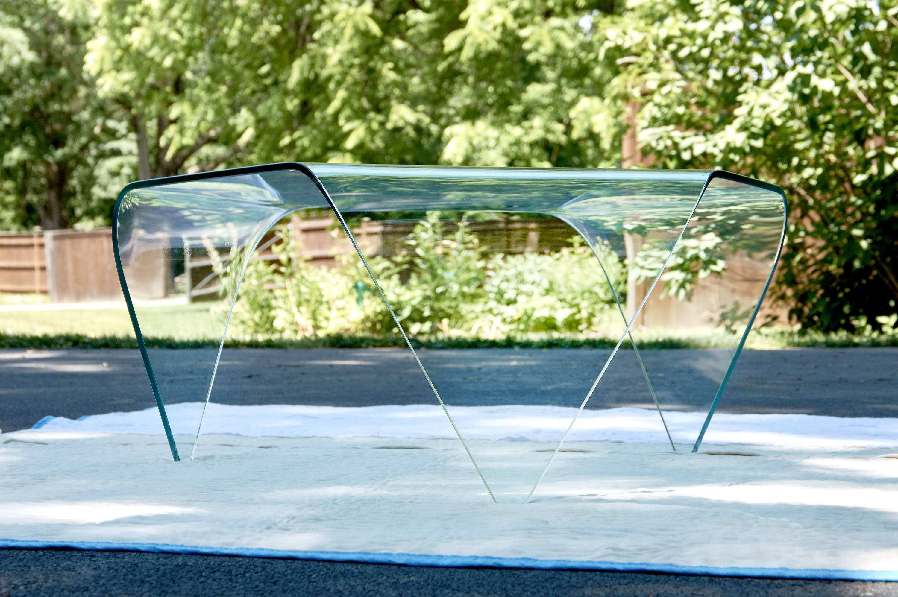 This is an amazing example of glass art in the form of a coffee table with a modern aesthetic. The workmanship and design is comparable to none and the clean lines will work with any decor. The clever three sided top is geometrically balanced by the