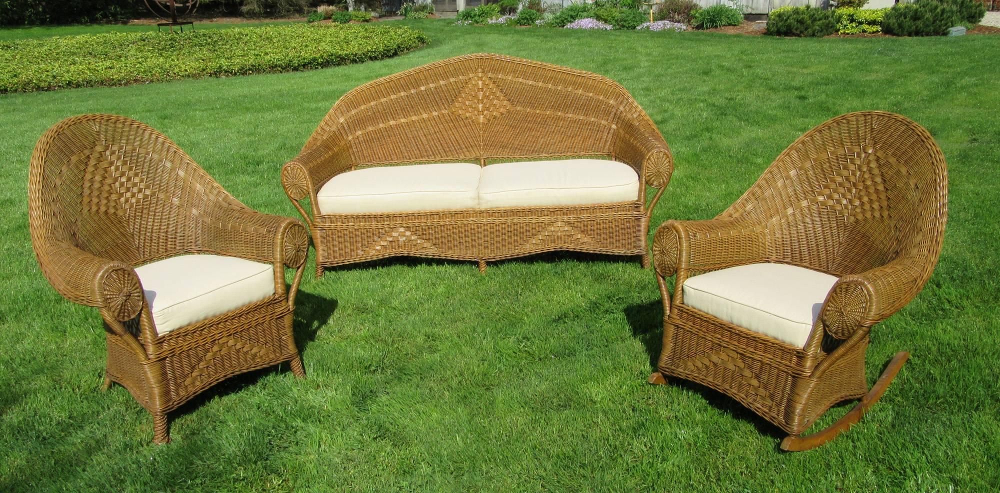 Three-piece Art Deco wicker set in original honey-toned natural stained finish. A fine example of high style American antique wicker made by the Heywood Wakefield Co., circa 1925. Matching set includes sofa, armchair, and rocking chair. Wide rolled