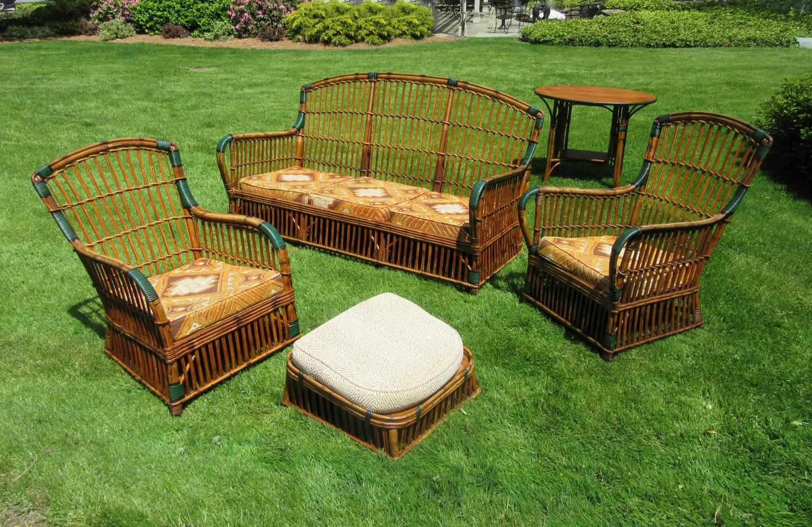 Five-piece matching Rattan suite in honey toned natural stained finish with green and black painted bandings. Stick Wicker style having evenly spaced single vertical rattan strands. 