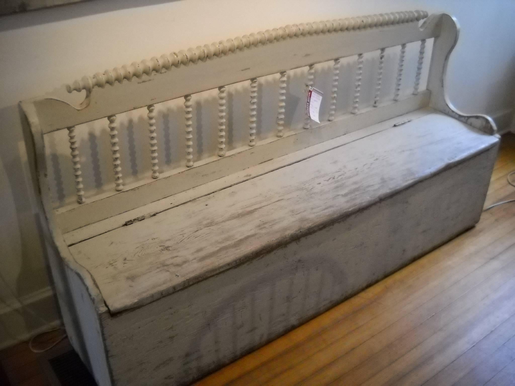 This gorgeous off-white painted bench is defined by many traits. The spindles get your attention first and it has a lift up seat with plenty of storage. The spindles across the back of the bench we have never seen before. This is a very special