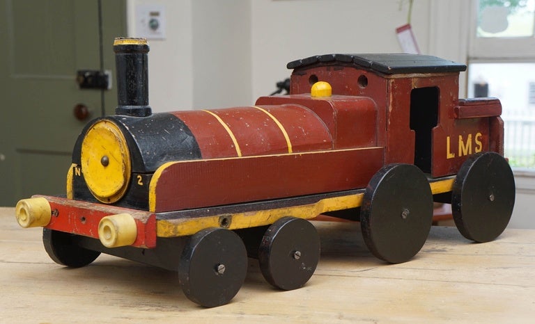 We collect children's toy trains at painted porch. You can always find 6-8 toys in our store. Most of them come from English homes, where a parent likely hand made the toy for his or her child. This one is colorful, in deep red, yellow and black