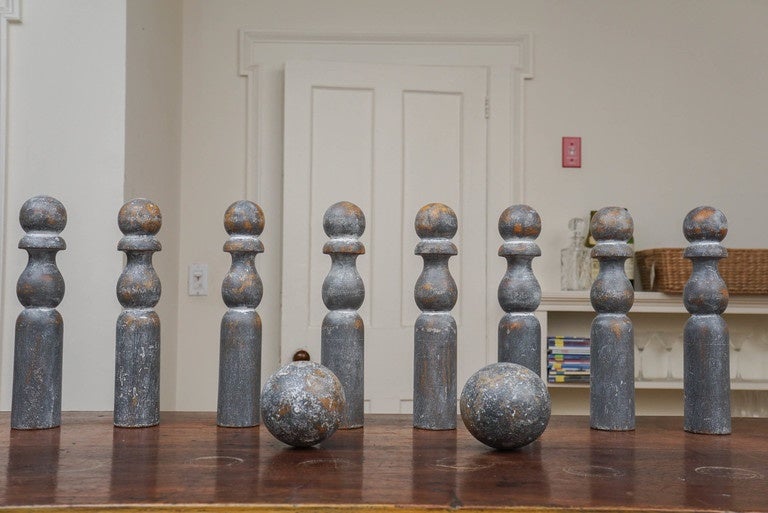 Skittles is the fore runner to bowling in the US. It is a similar game and come in all sizes. It was not played on a smooth lane but on dirt, lawn etc. this set has original paint and has a silver marbleized look. There are eight pins and two balls.