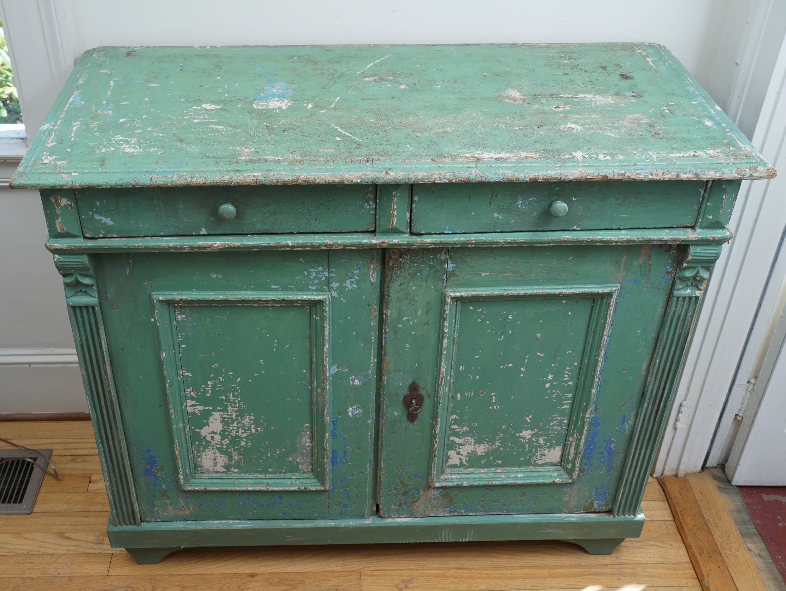It is the color green, combined with the fluting on the front of each side that will attract your attention the most on this two-drawer, two-door buffet. Complete with original lock and key, this is a stunning piece from one of our favorite French