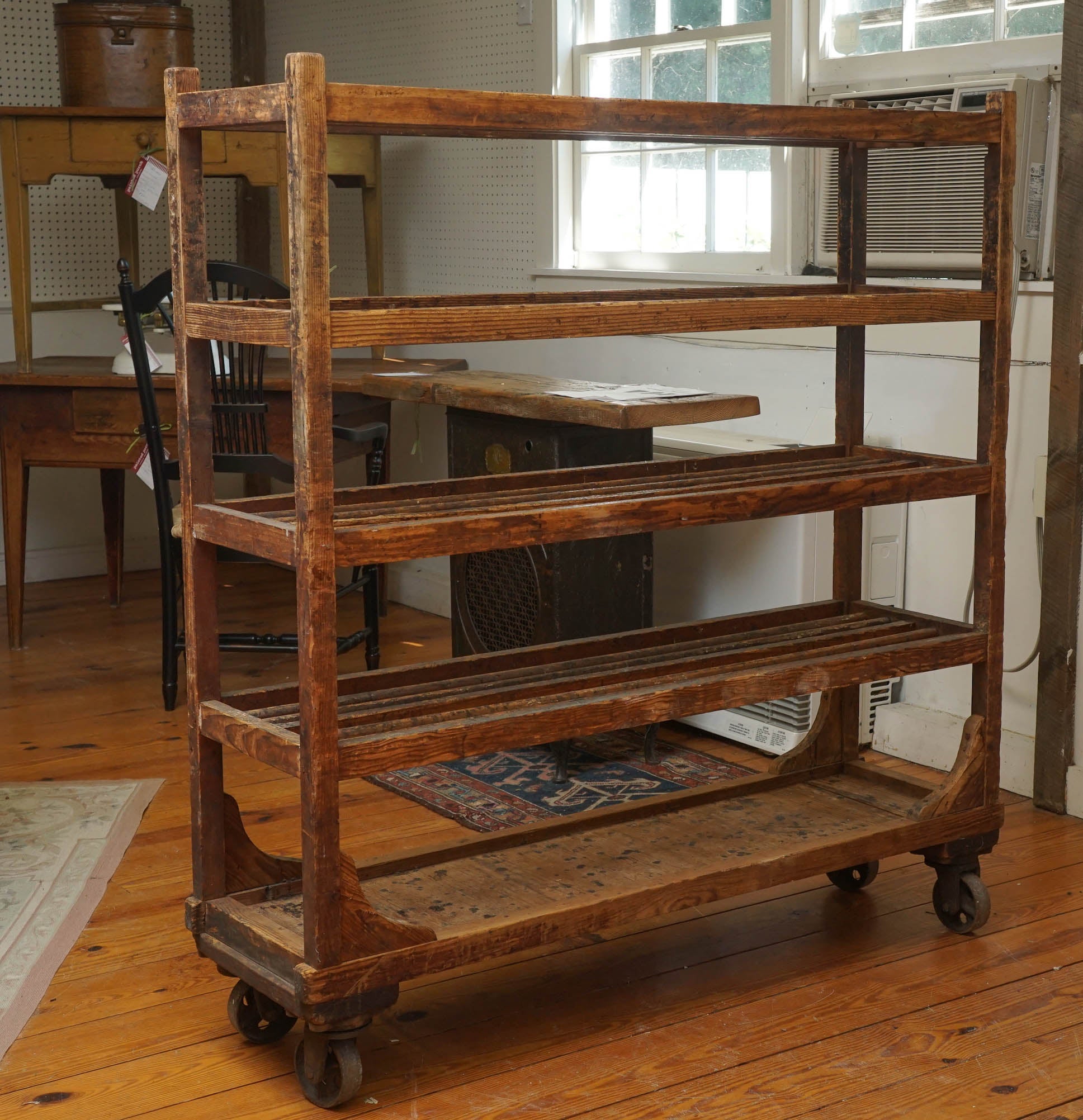 The French use these wooden trolleys as bakery racks to cool down pies. It is what the English use as shoe drying racks. This piece has original casters and the bottom shelf is solid wood. A most useful piece of furniture to put in a kitchen for