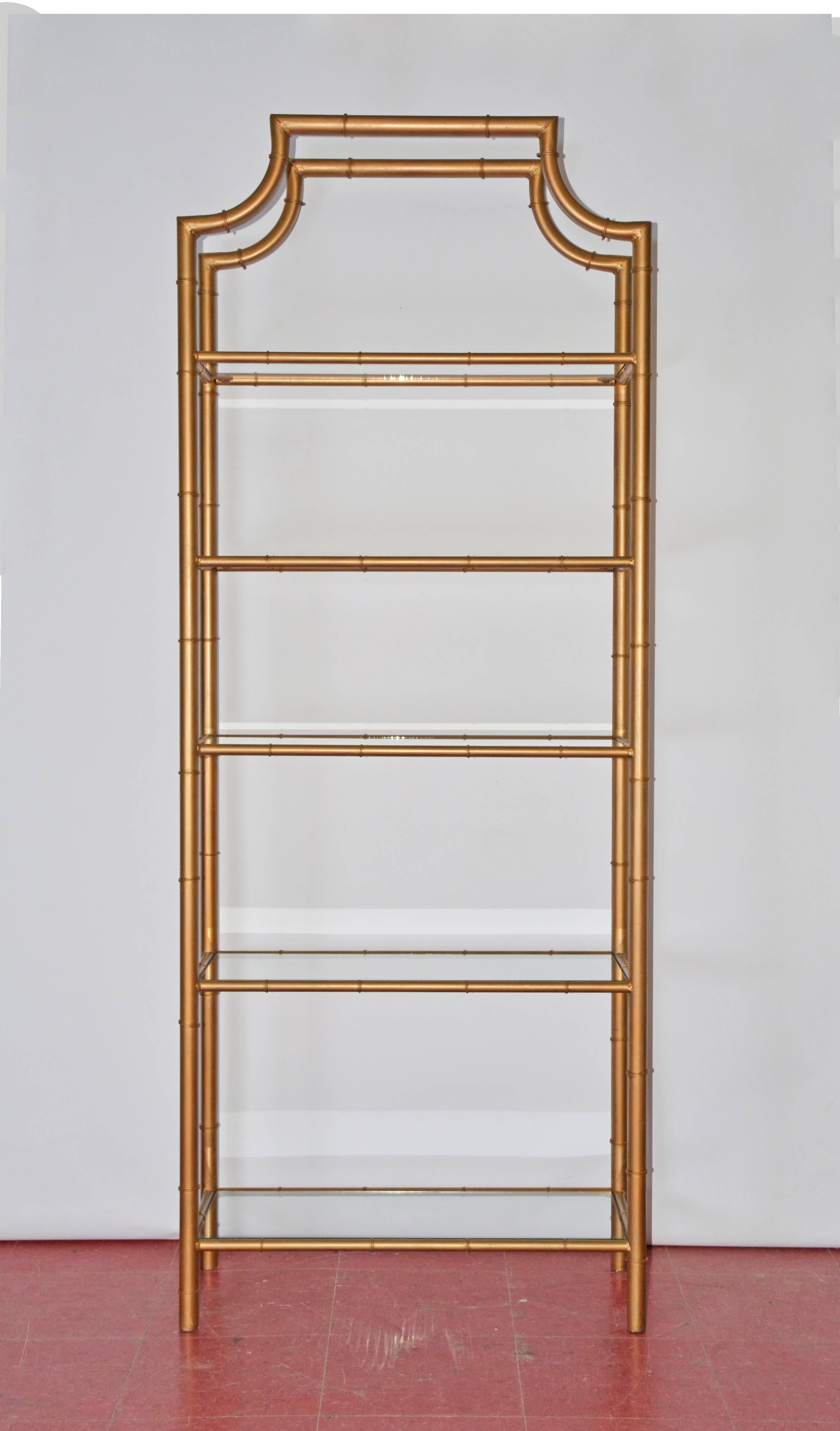 The Mid-Century faux bamboo pagoda style gold gilt metal etagere shelving unit has five glass shelves inset in frames. Great as book shelve or special decorative collection.

Height of each shelf from top to bottom: 13.50