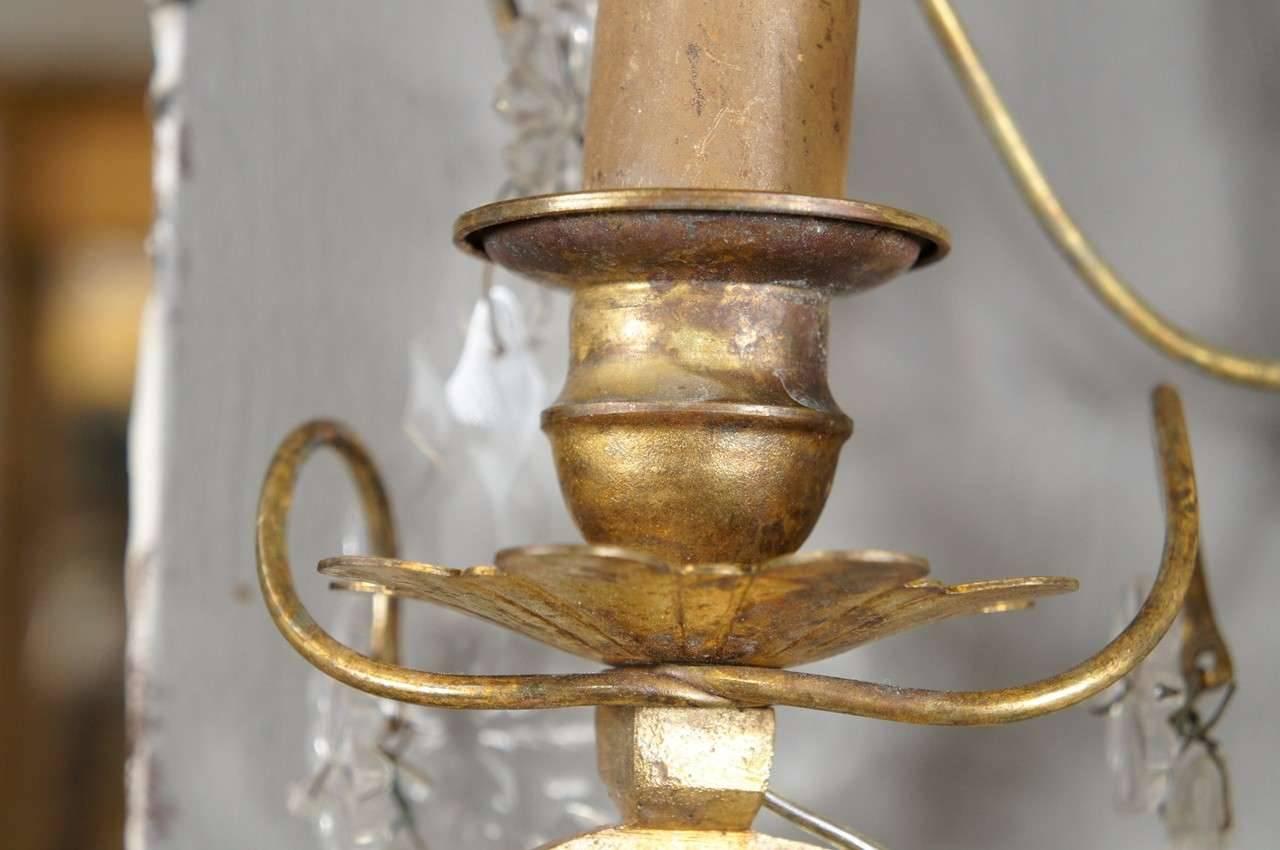 French Rococo-style gilt-metal and crystal sconces electrified for small socket light bulbs. Crystal drops and florets.
Backplate measures 2