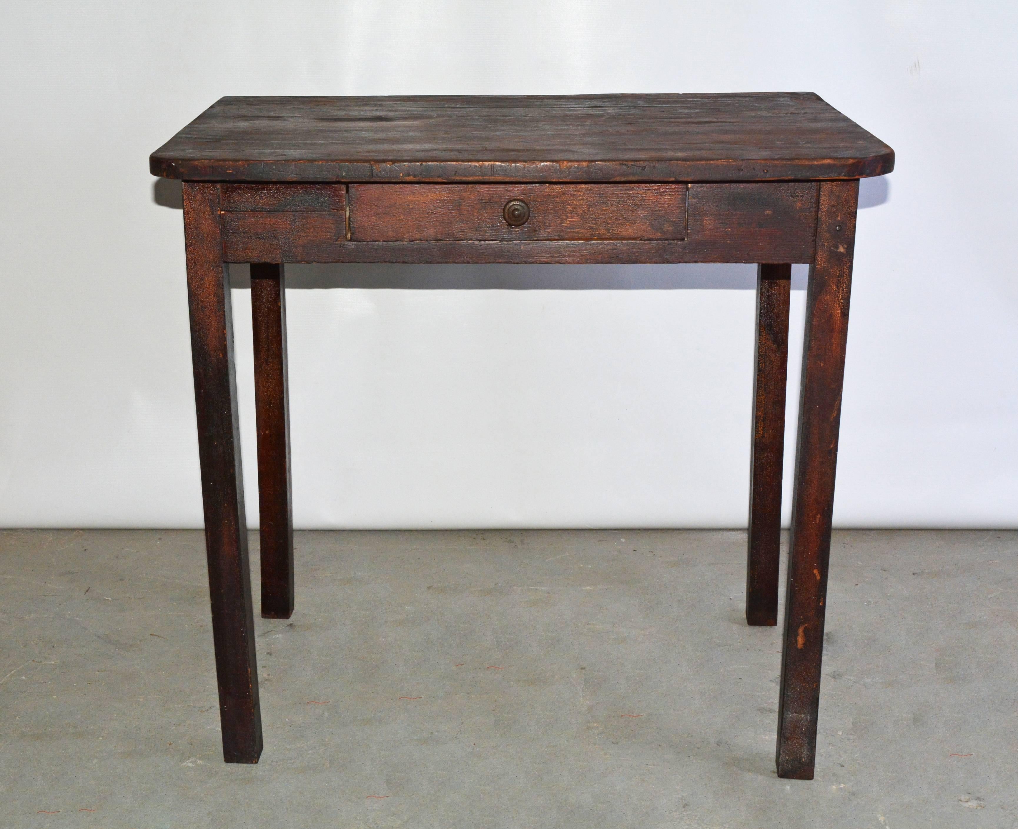 The small vintage country table is protected with brown stain and has a single dovetailed drawer. The front corners of the top are rounded and the back corners are squared off. Measure: The 30