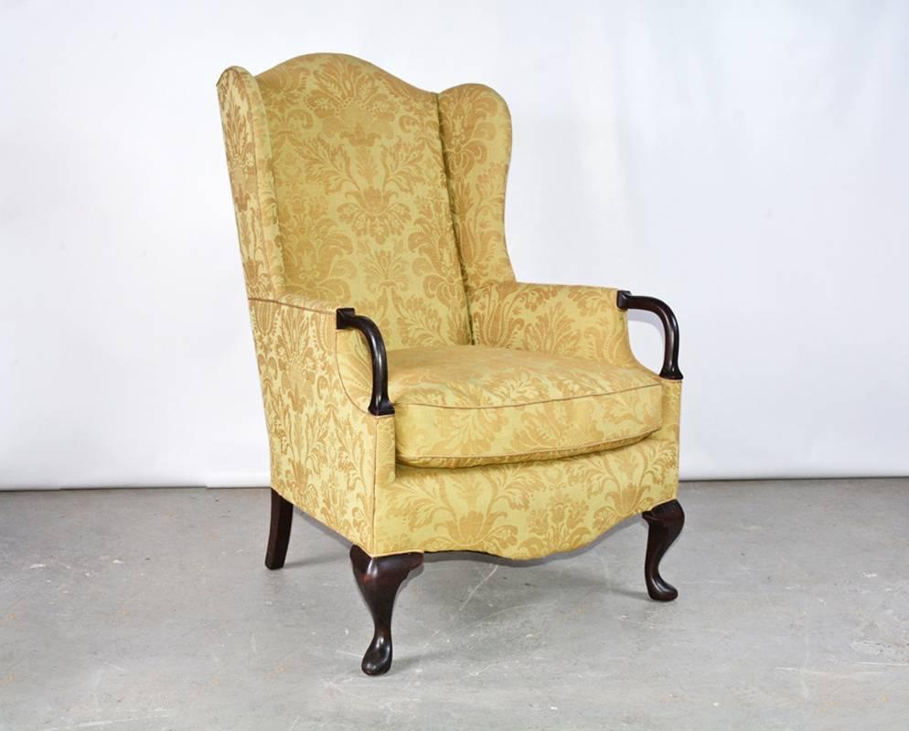 The vintage wingback armchair has wood extensions to the arms and cabriole legs, and is newly upholstered in a gold damask linen fabric. Easily comfortable.

Measures: Arm height 24.50