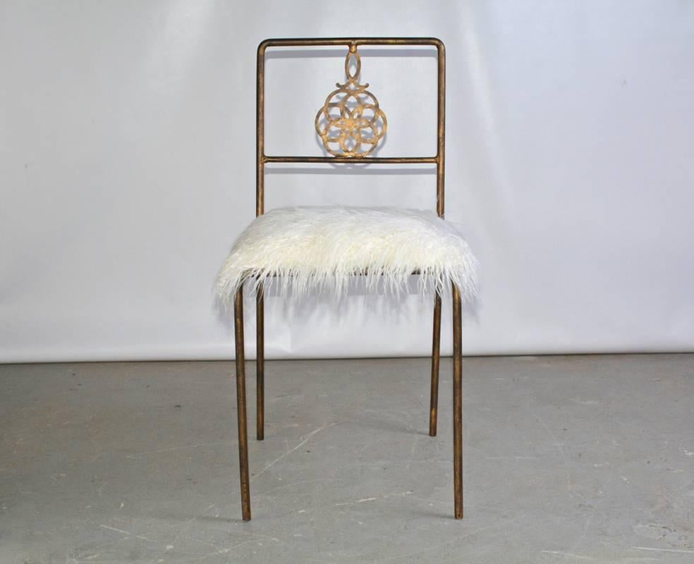 The vintage wrought Iron desk or vanity chair with a rubbed gilt finish has a medallion back and a white shag faux fur newly upholstered seat.